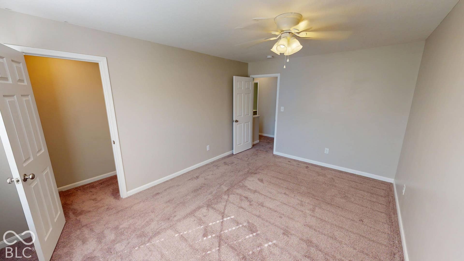 Bedroom # 2 | Neutral tone wall paint, carpeted flooring, and a ceiling-mounted fan with integrated lighting