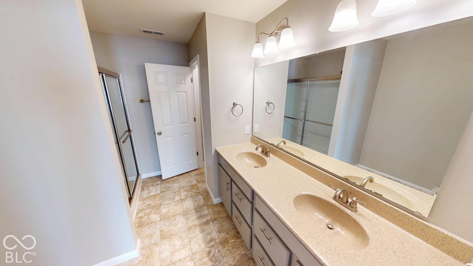 Dual vanity with integrated sinks, ample countertop space, and a large wall-mounted mirror
