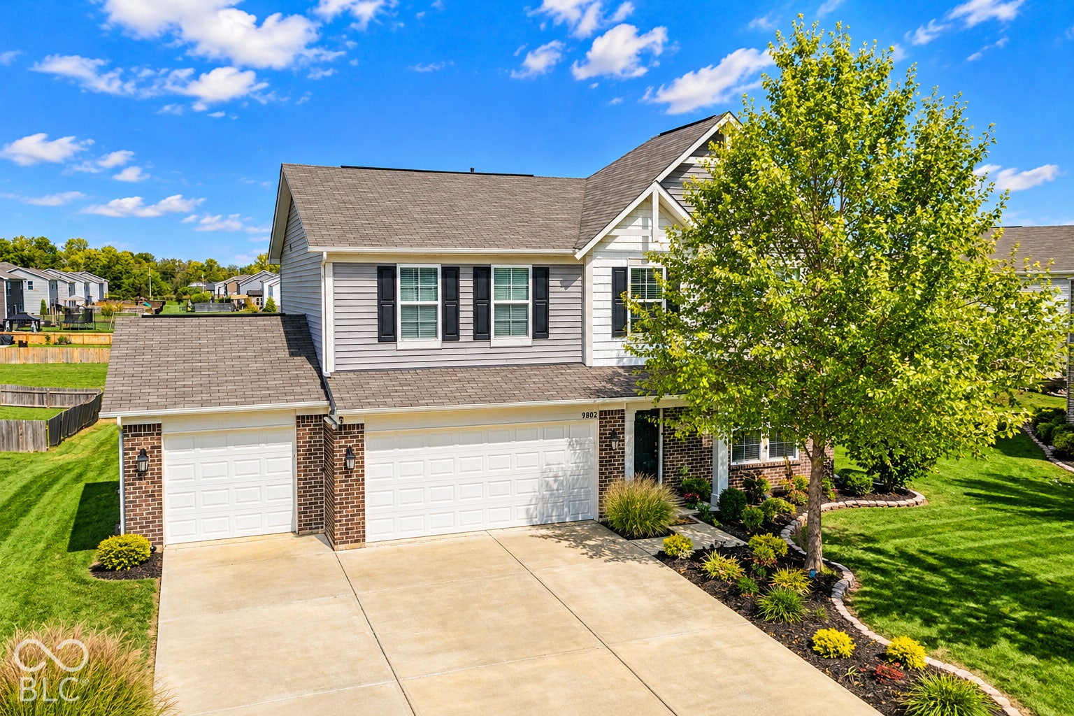 *AI - Color Enhancement* Two-story residence with a multi-car driveway, attached garage, and a gabled roofline