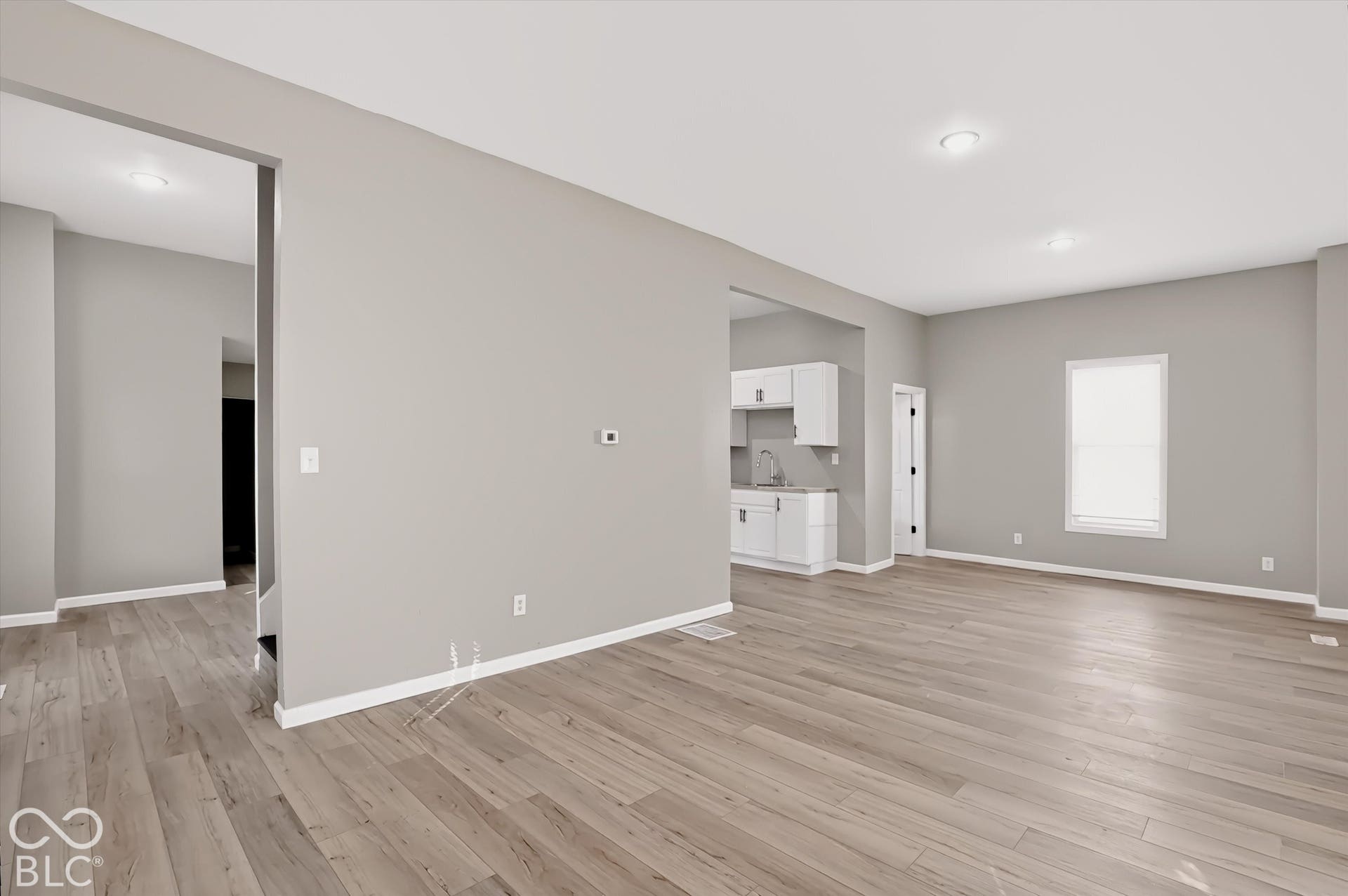 Neutral interior featuring wood-finish flooring, recessed lighting, and crisp white trim