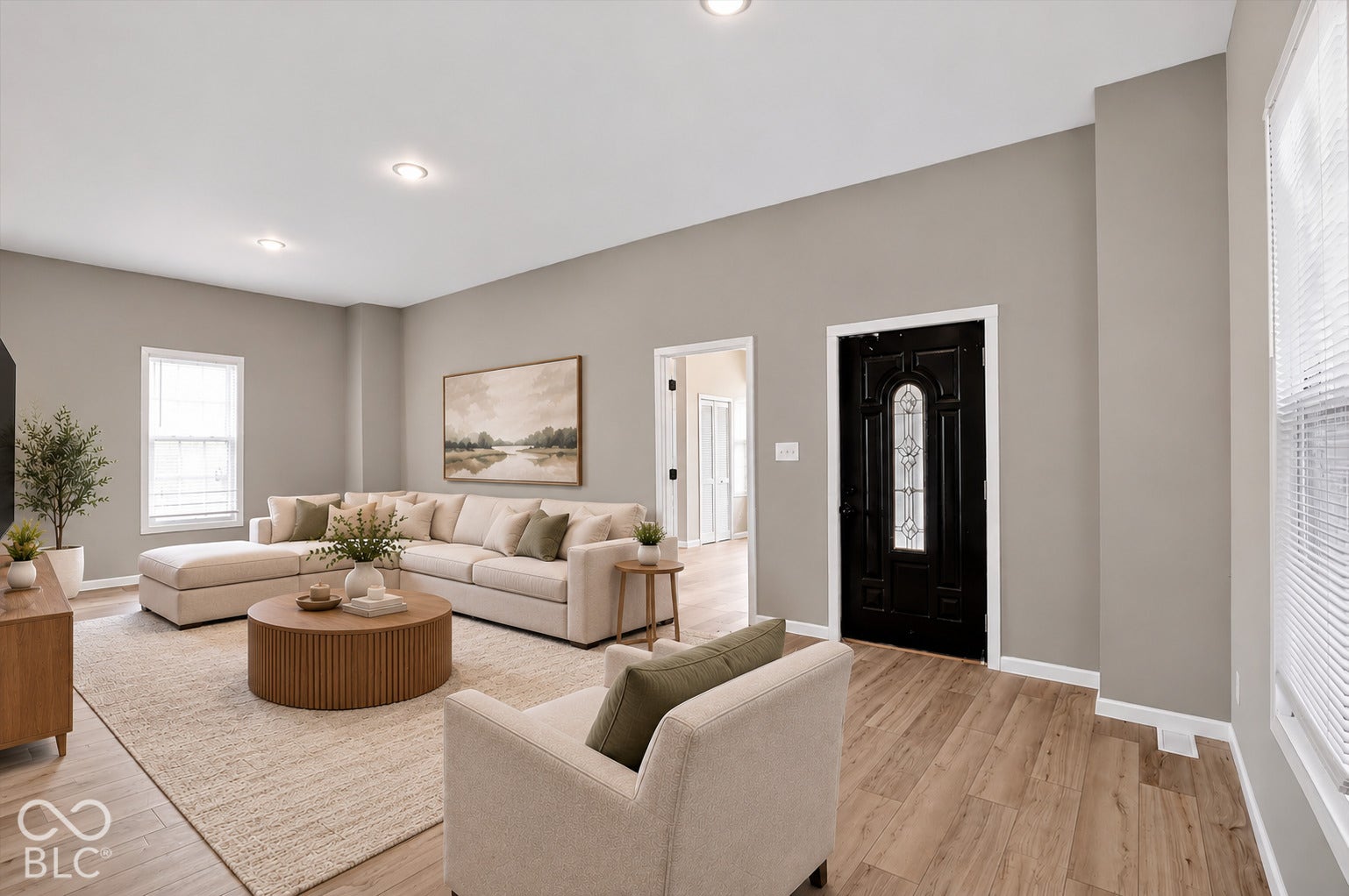 Virtually Altered - Neutral-toned interior featuring wood-finish flooring, recessed lighting, and a black front door with decorative glass inlay