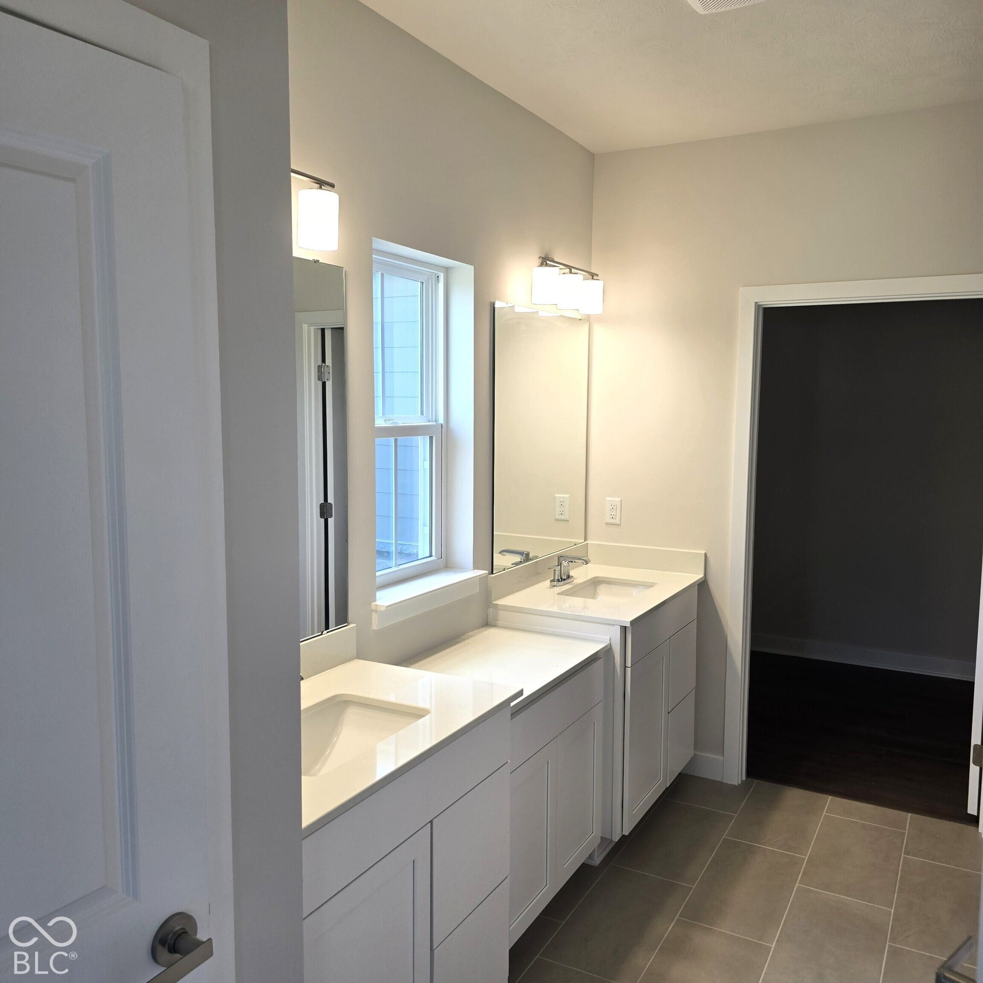 Dual vanity featuring white shaker-style cabinetry, integrated rectangular sinks, and substantial countertop space