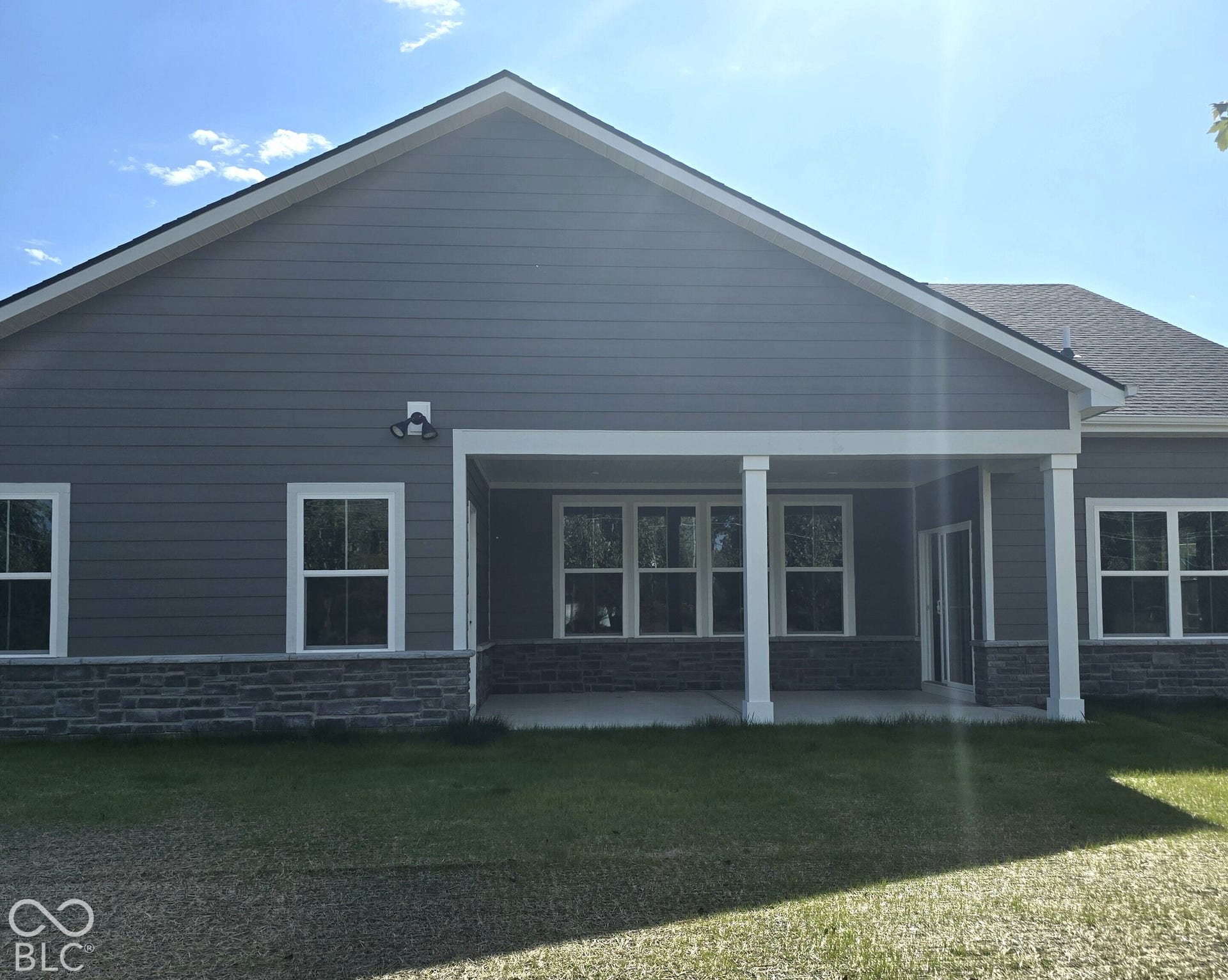 Rear exterior featuring siding and stone accents