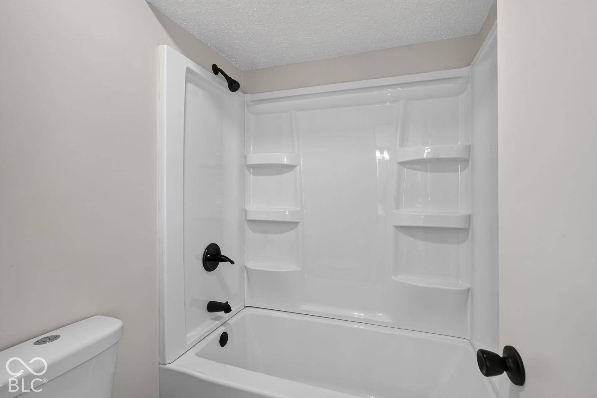 White bathtub and shower combination with matte black fixtures