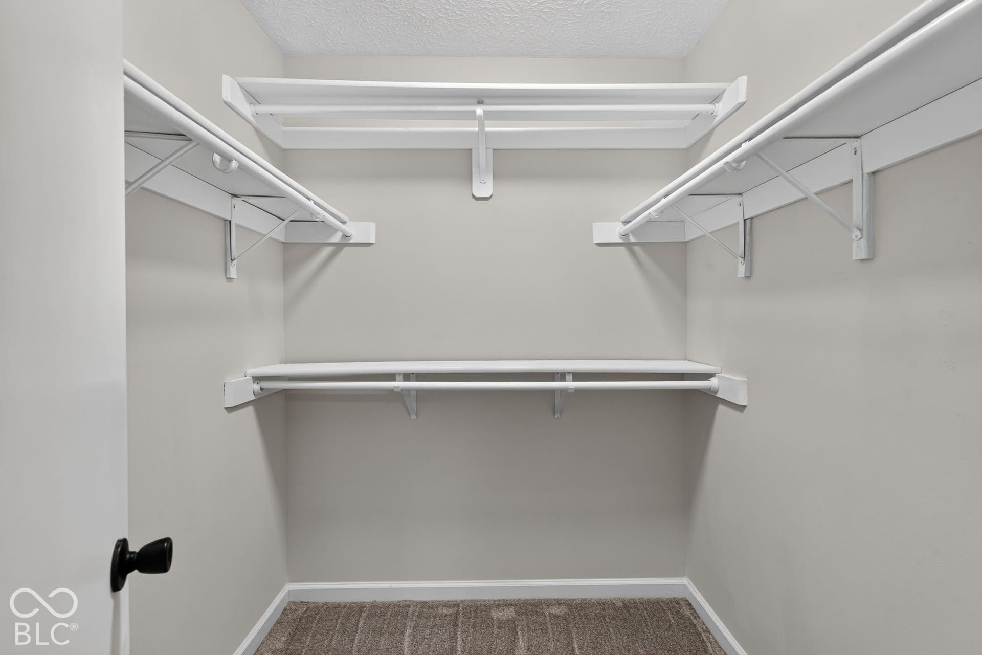 Built-in shelving with hanging rods and carpet flooring