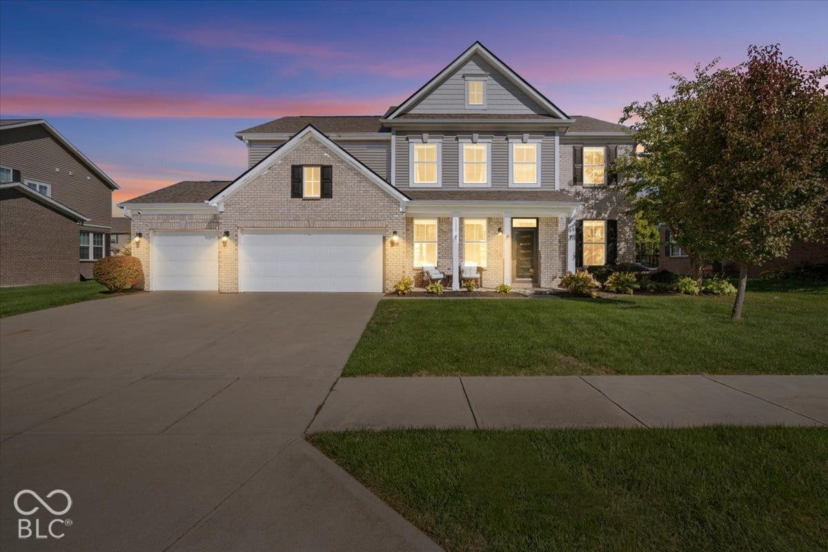 5570 W Stream Drive, McCordsville, IN 46055 Virtually Altered - Brick and siding exterior with a covered front porch, dual garage doors, and a concrete driveway