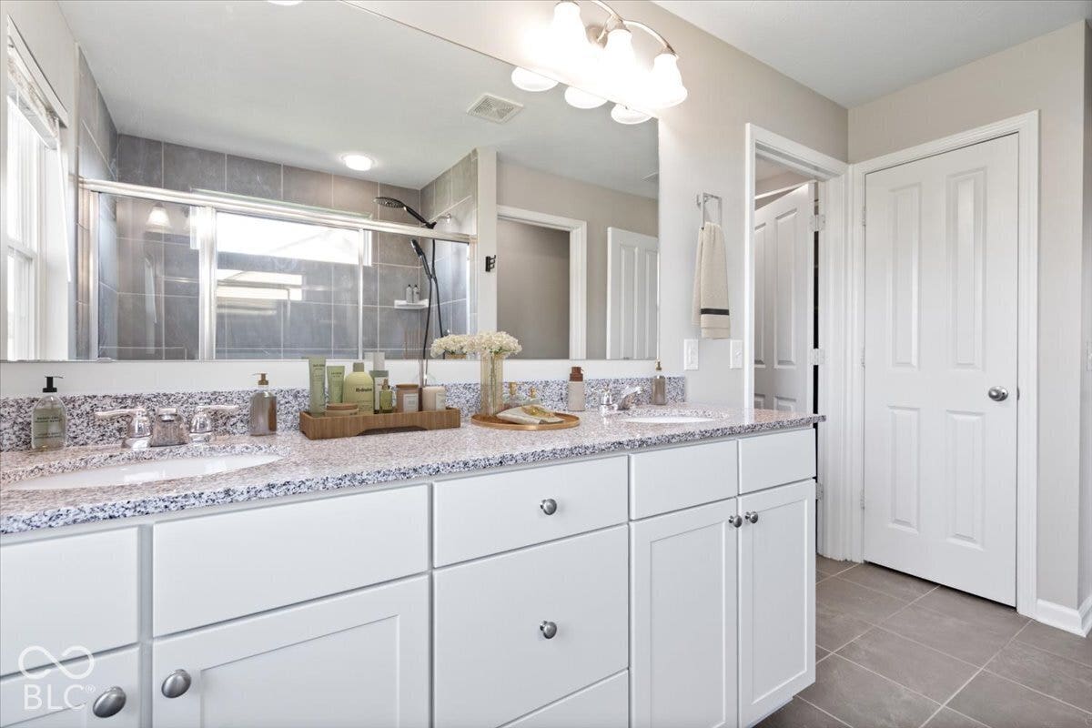 5570 W Stream Drive, McCordsville, IN 46055 Virtually Altered - Dual vanity with light-toned speckled countertop, undermount sinks, and white shaker-style cabinetry