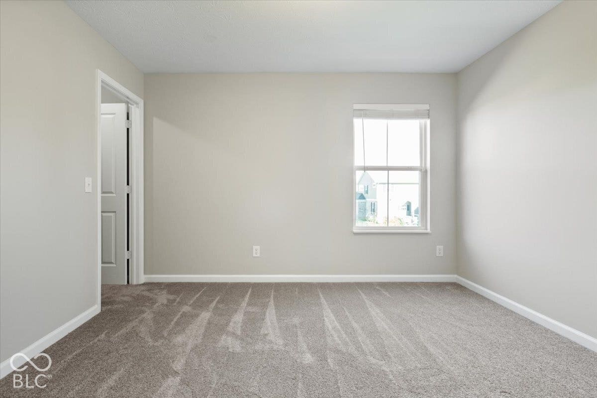 5570 W Stream Drive, McCordsville, IN 46055 Neutral wall paint, plush carpet flooring, white trim, and a window with blinds