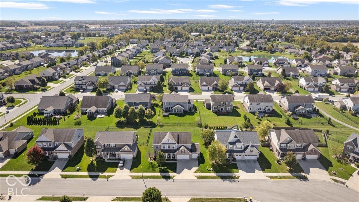 5570 W Stream Drive, McCordsville, IN 46055 Residential neighborhood featuring a variety of single-family homes, mature landscaping, paved streets, and a prominent pond
