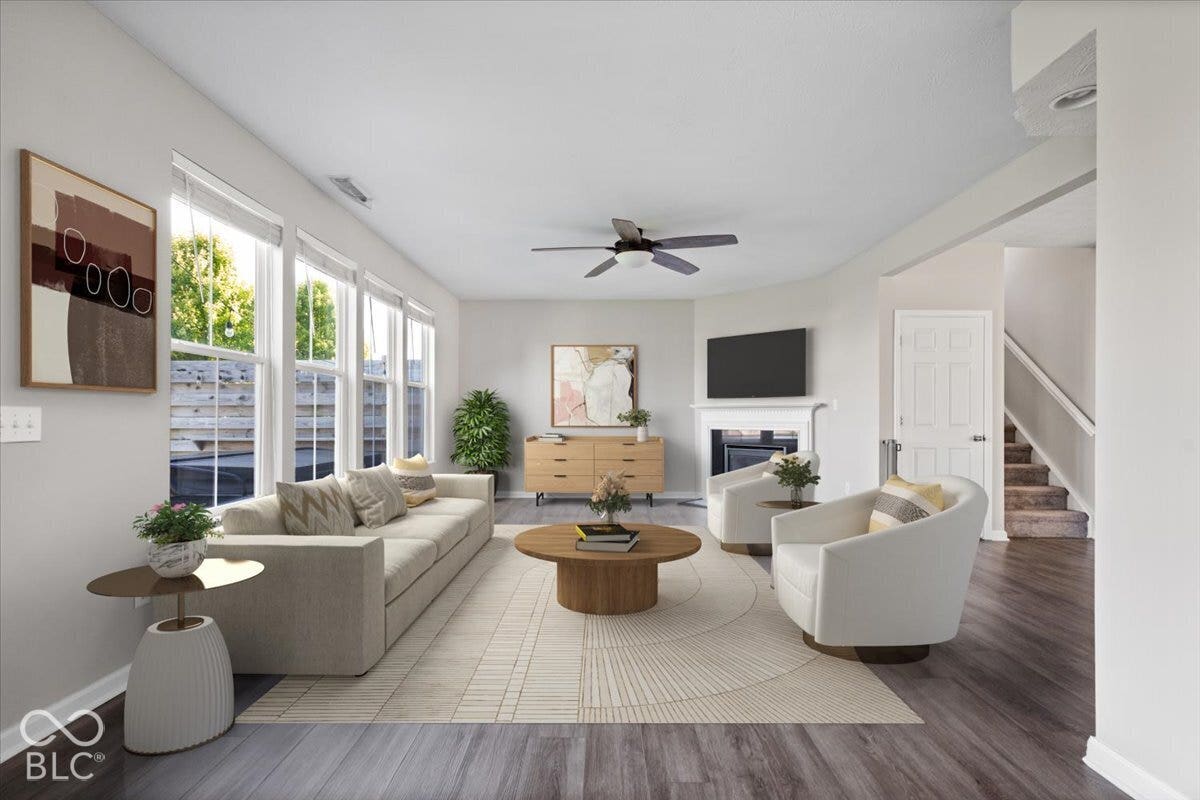 5570 W Stream Drive, McCordsville, IN 46055 Virtually Altered - Spacious living area featuring abundant natural light, wood-finish flooring, and a ceiling fan