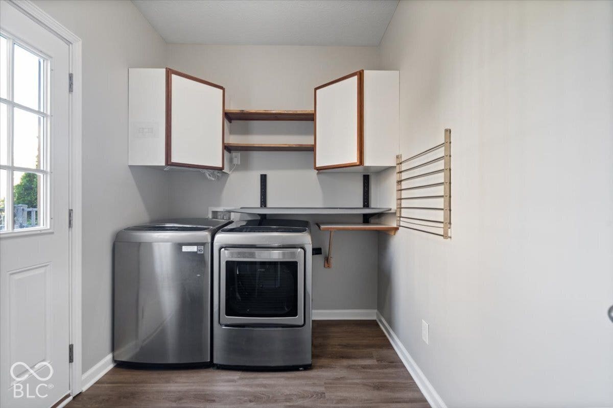 5570 W Stream Drive, McCordsville, IN 46055 Laundry area featuring wood-finish flooring, white cabinetry with wood-tone accents, open shelving, and a wall-mounted drying rack