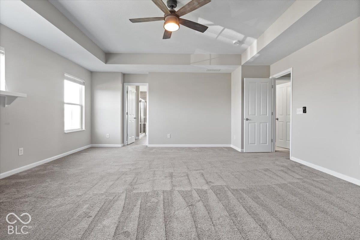 5570 W Stream Drive, McCordsville, IN 46055 Tray ceiling featuring a wood-finish ceiling fan with integrated lighting