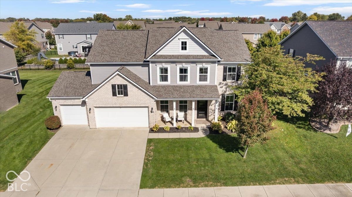 5570 W Stream Drive, McCordsville, IN 46055 Brick and siding exterior with a gabled roofline, two-car garage, concrete driveway, and a front porch