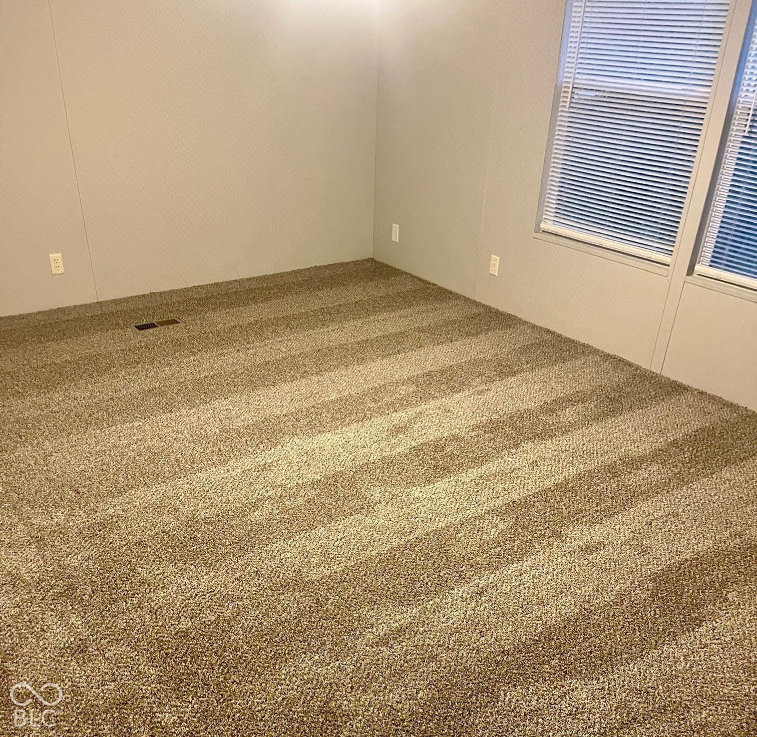 Light beige walls complement the patterned carpet flooring