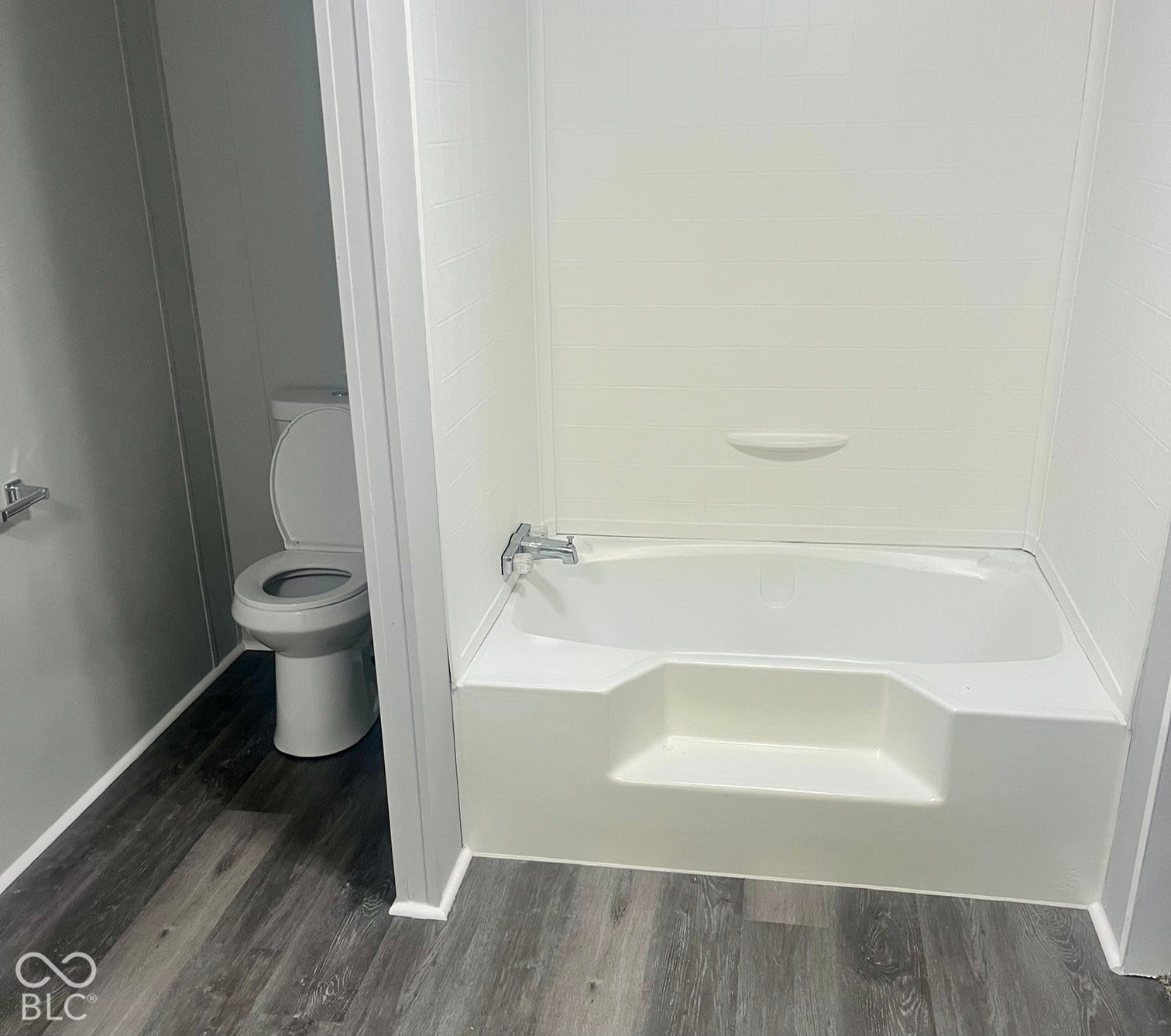 White bathtub with integrated step and chrome fixtures