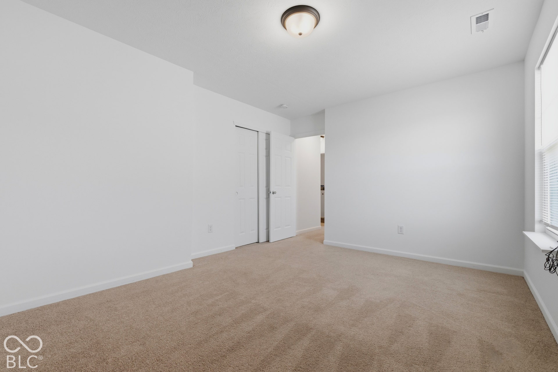 10525 Broadford Street, Indianapolis, IN 46239 Neutral tone carpeting, white walls, flush mount ceiling light fixture, and window with blinds