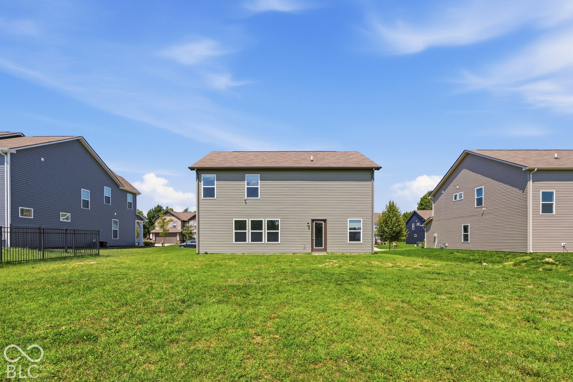 10525 Broadford Street, Indianapolis, IN 46239 Rear elevation featuring vertical siding, multiple windows, and a glass-paneled entry door