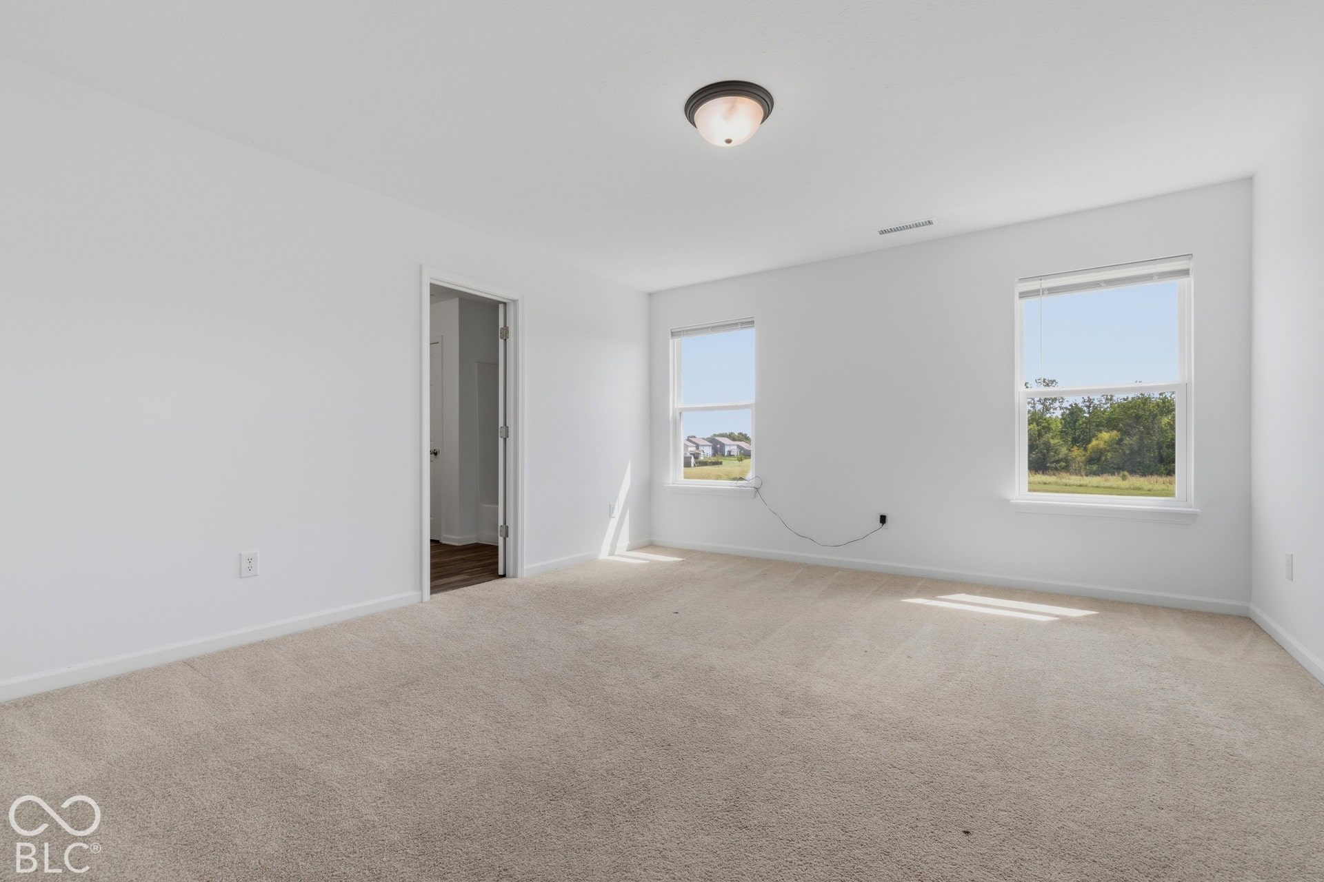 10525 Broadford Street, Indianapolis, IN 46239 Spacious room featuring neutral carpeting, white walls, two windows, and a flush mount ceiling light