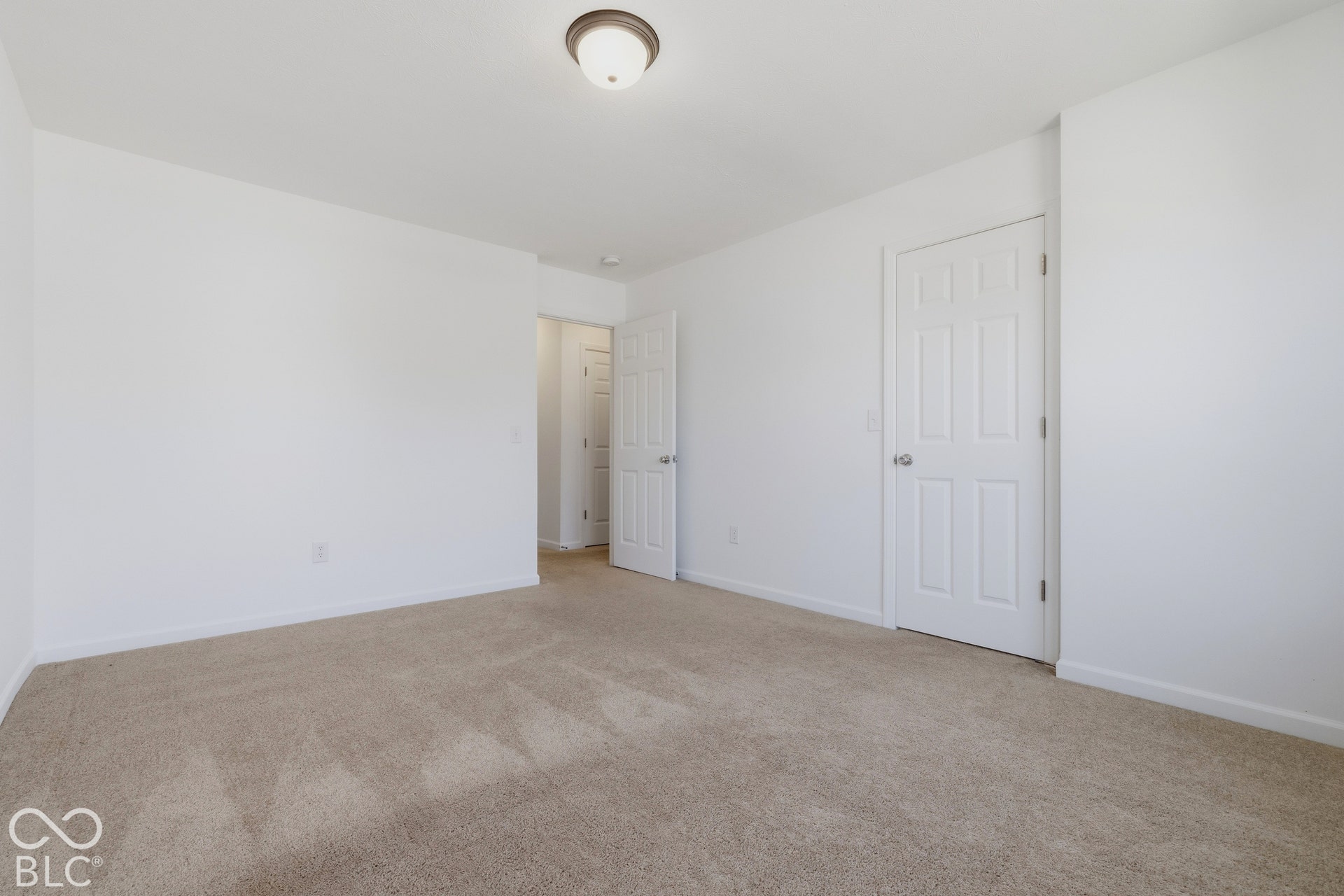 10525 Broadford Street, Indianapolis, IN 46239 Neutral-toned carpet flooring and white painted walls, featuring a flush mount ceiling light