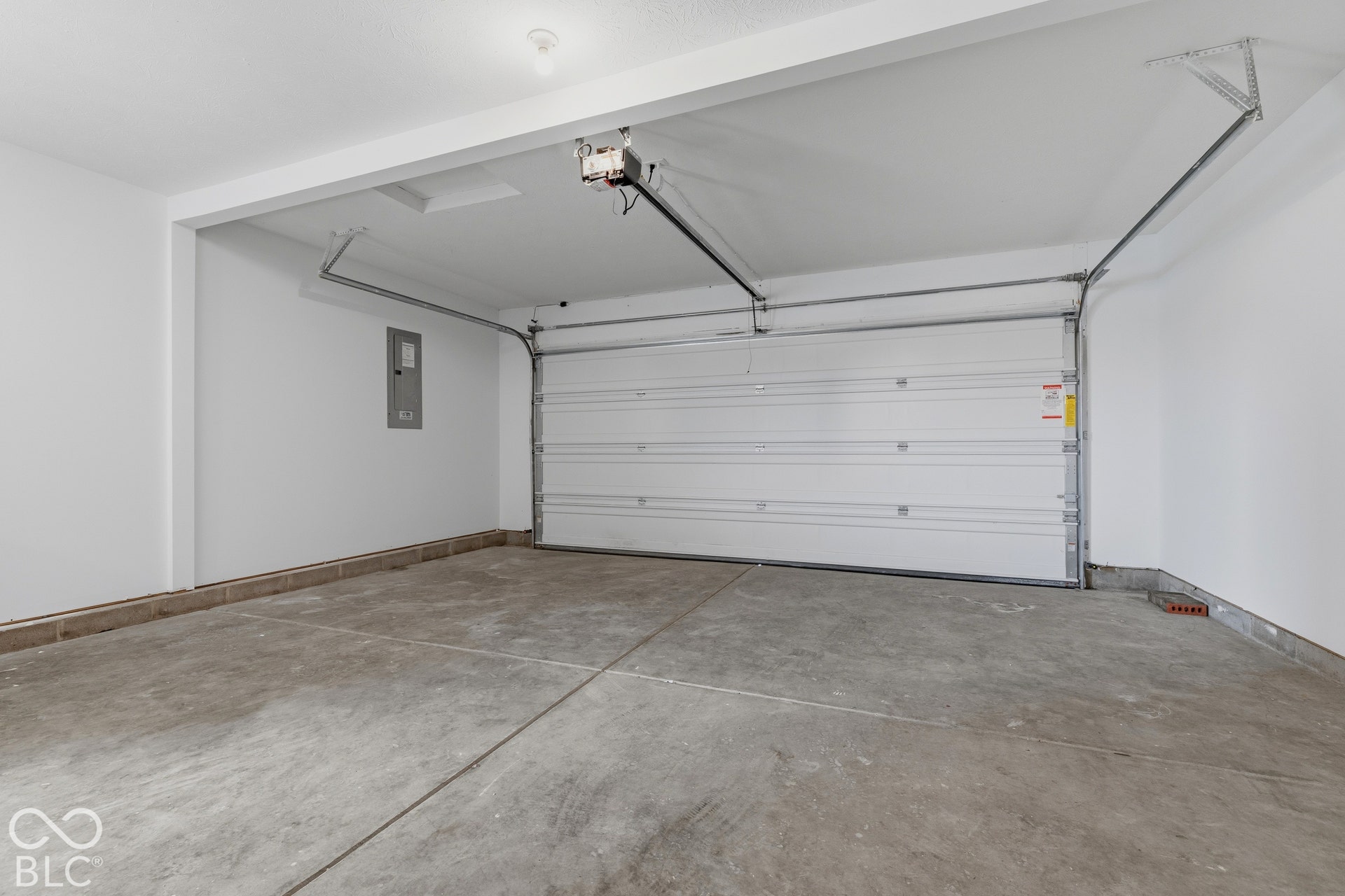 10525 Broadford Street, Indianapolis, IN 46239 Concrete flooring, white walls, overhead lighting, garage door, and visible electrical panel