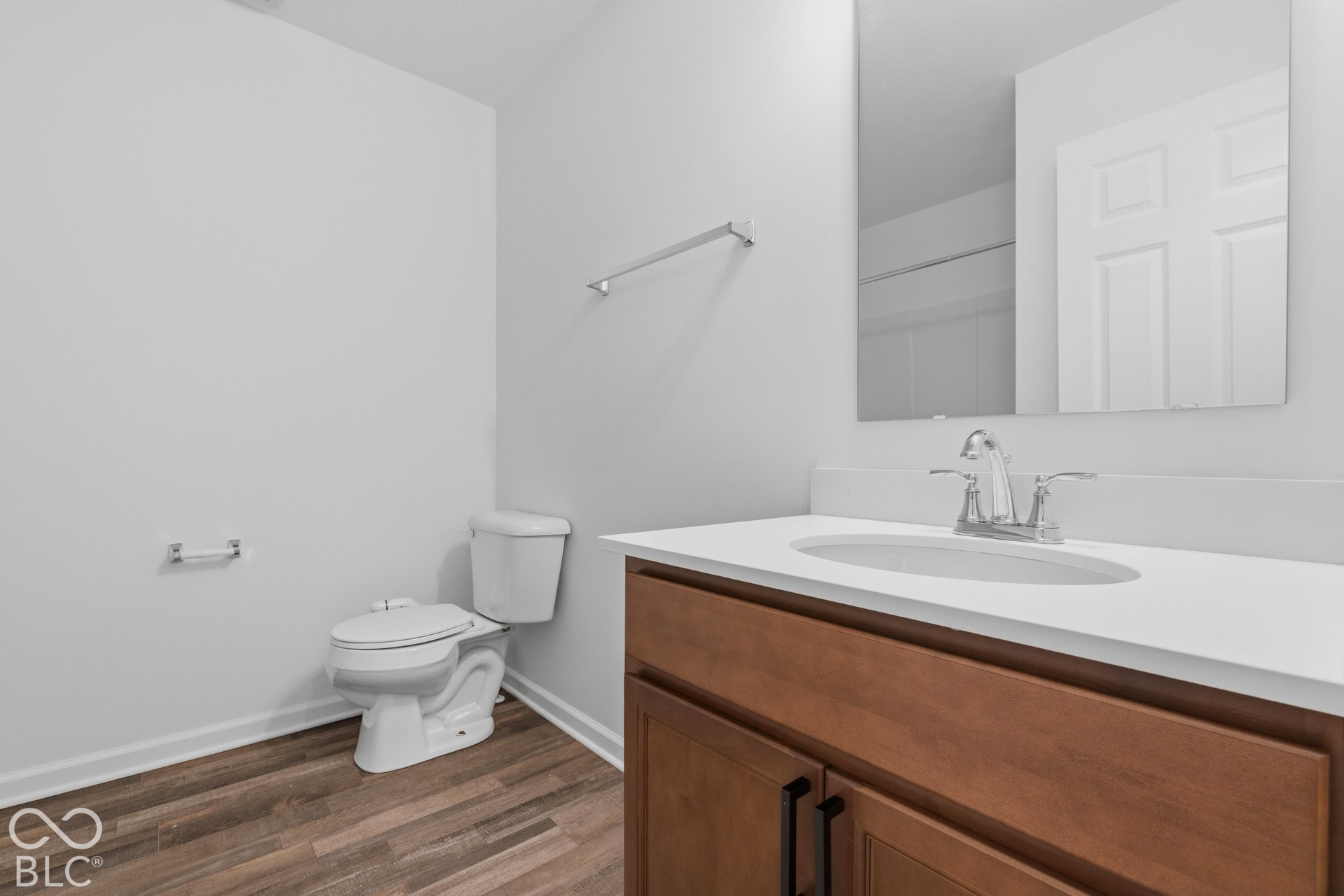 10525 Broadford Street, Indianapolis, IN 46239 Wood-finish flooring, white walls, and a wood vanity with a white countertop and integrated sink