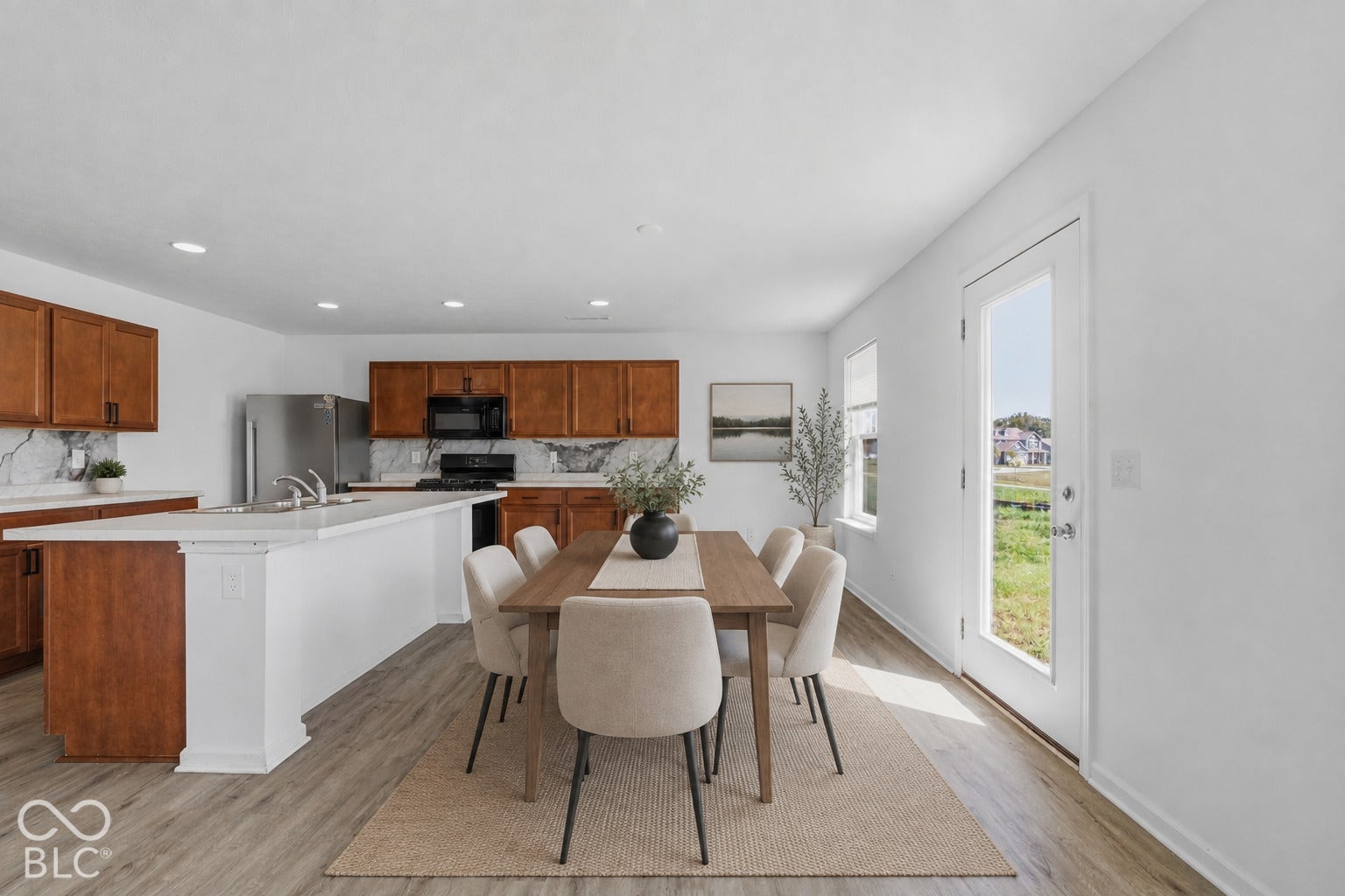 10525 Broadford Street, Indianapolis, IN 46239 Virtually Altered - Open-concept kitchen and dining area featuring wood-finish flooring, white walls, and recessed lighting