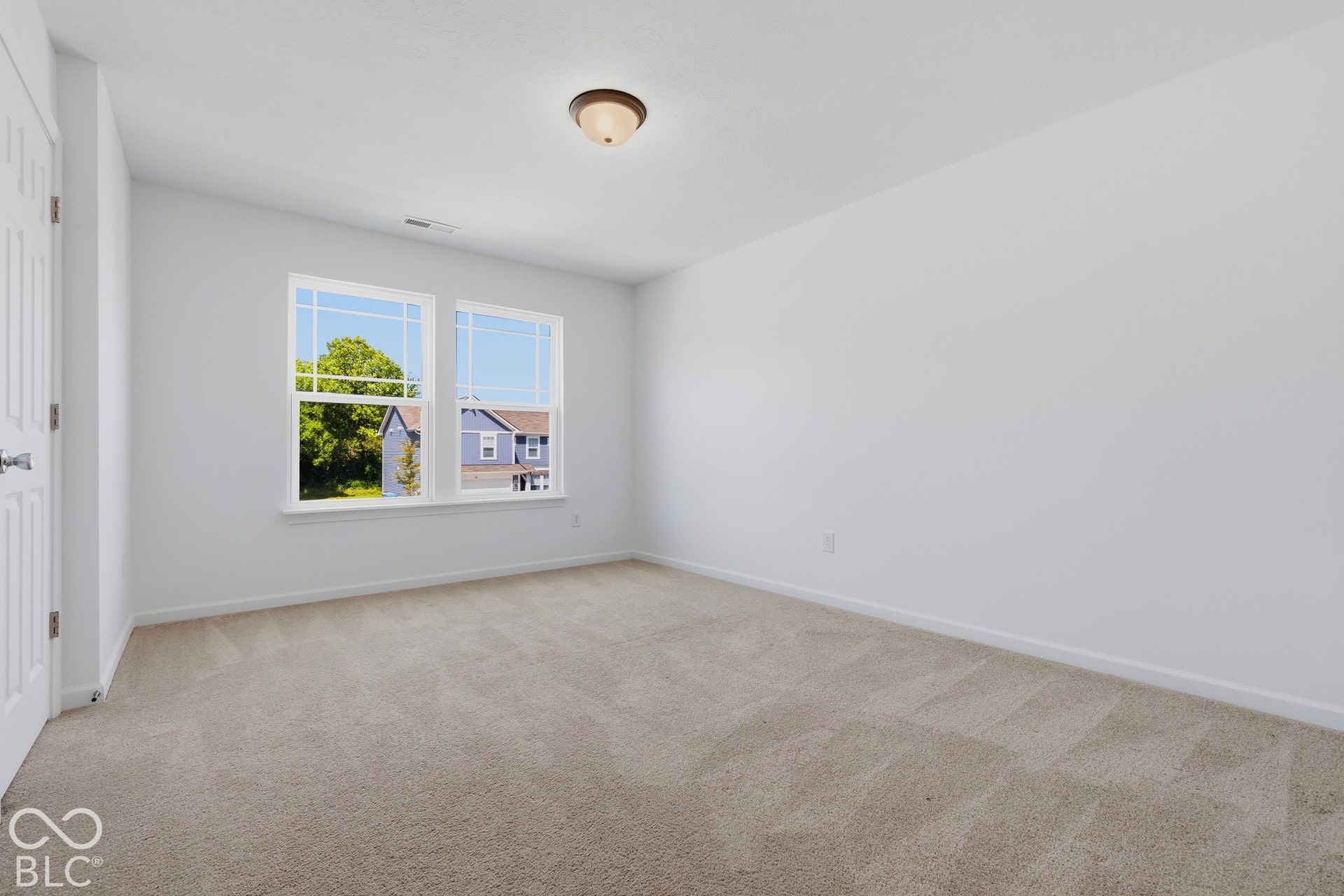 10525 Broadford Street, Indianapolis, IN 46239 Neutral wall color, carpeted flooring, double windows, flush mount ceiling light fixture, and a paneled door