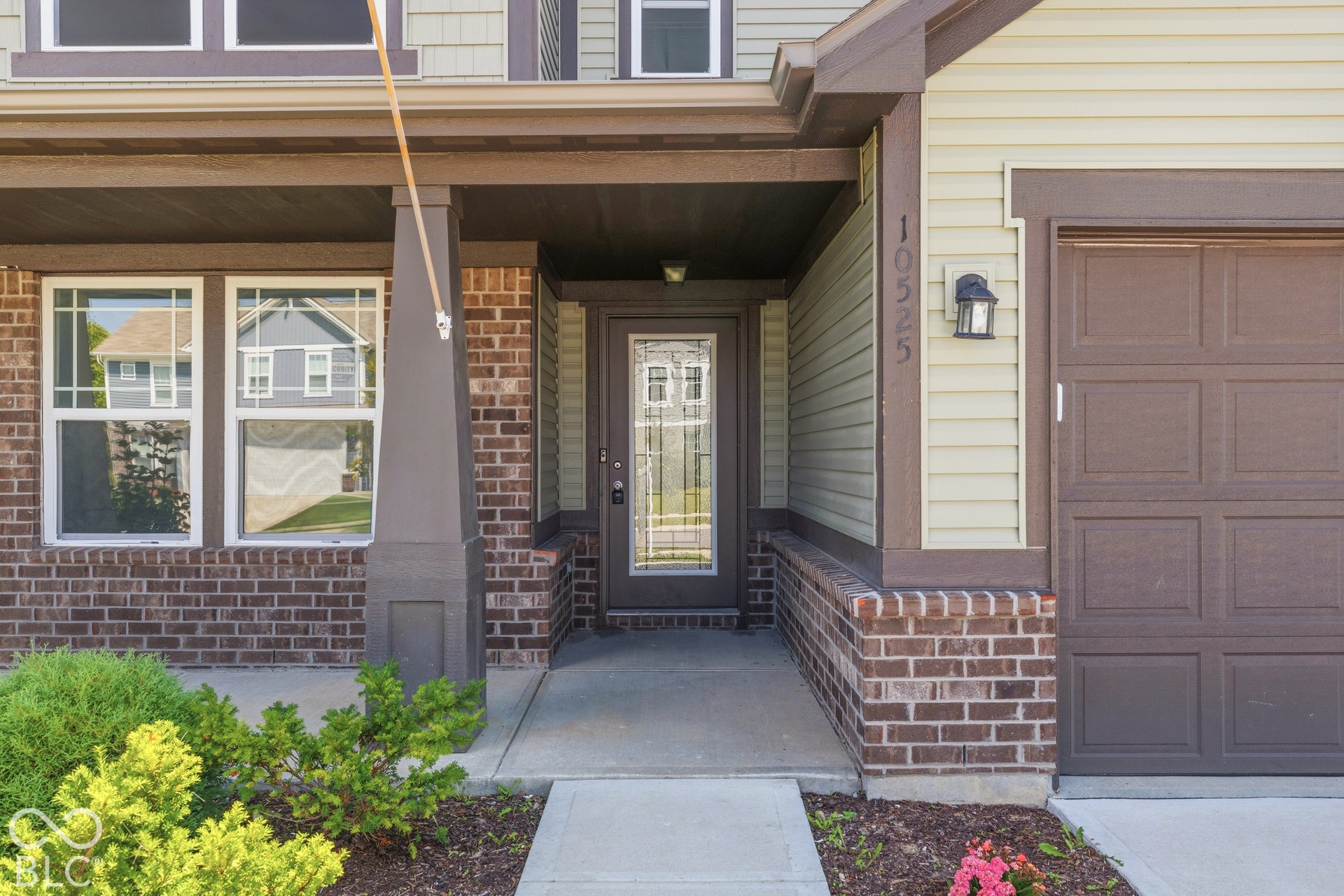 10525 Broadford Street, Indianapolis, IN 46239 Brick and siding exterior with a covered entry, decorative glass front door, integral garage, and exterior lighting fixture