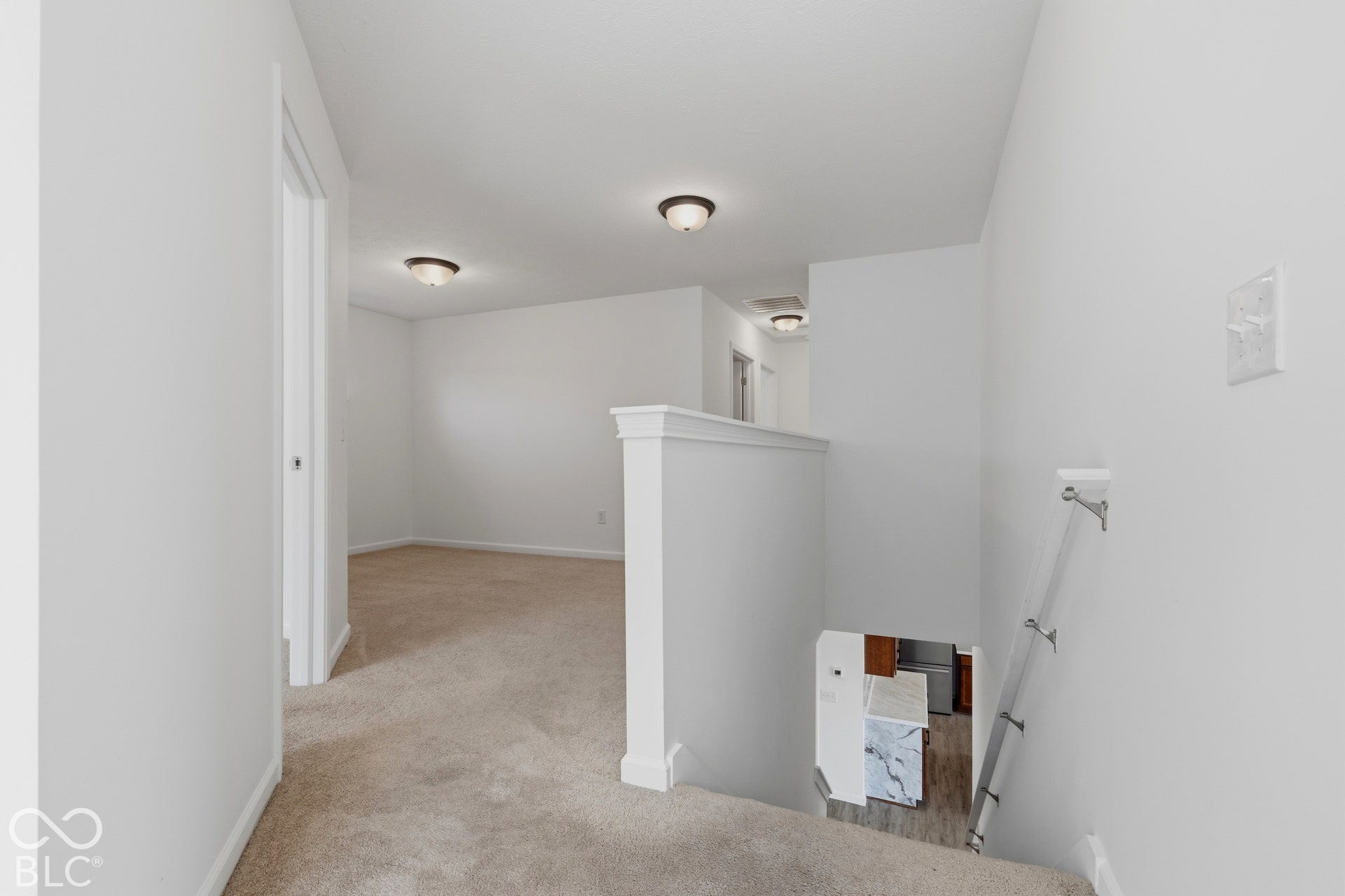 10525 Broadford Street, Indianapolis, IN 46239 Carpeted hallway with white walls, recessed lighting, and a white stair railing