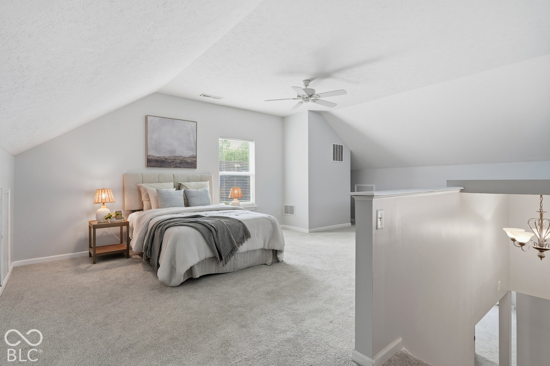 Carpeted room featuring sloped ceilings, a window, and a ceiling fan
