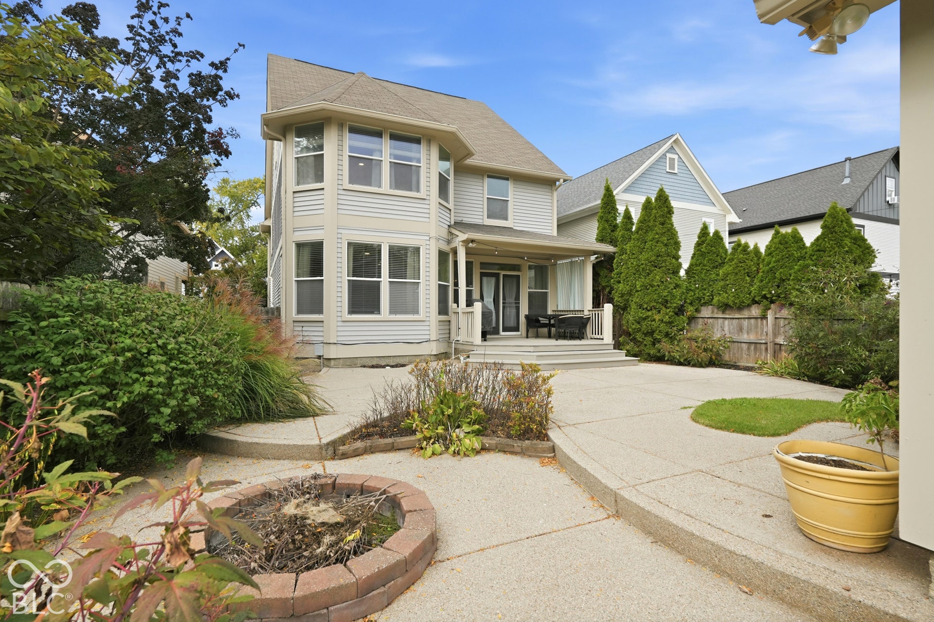 Two-story exterior with light-colored siding, a covered patio, and multi-pane windows
