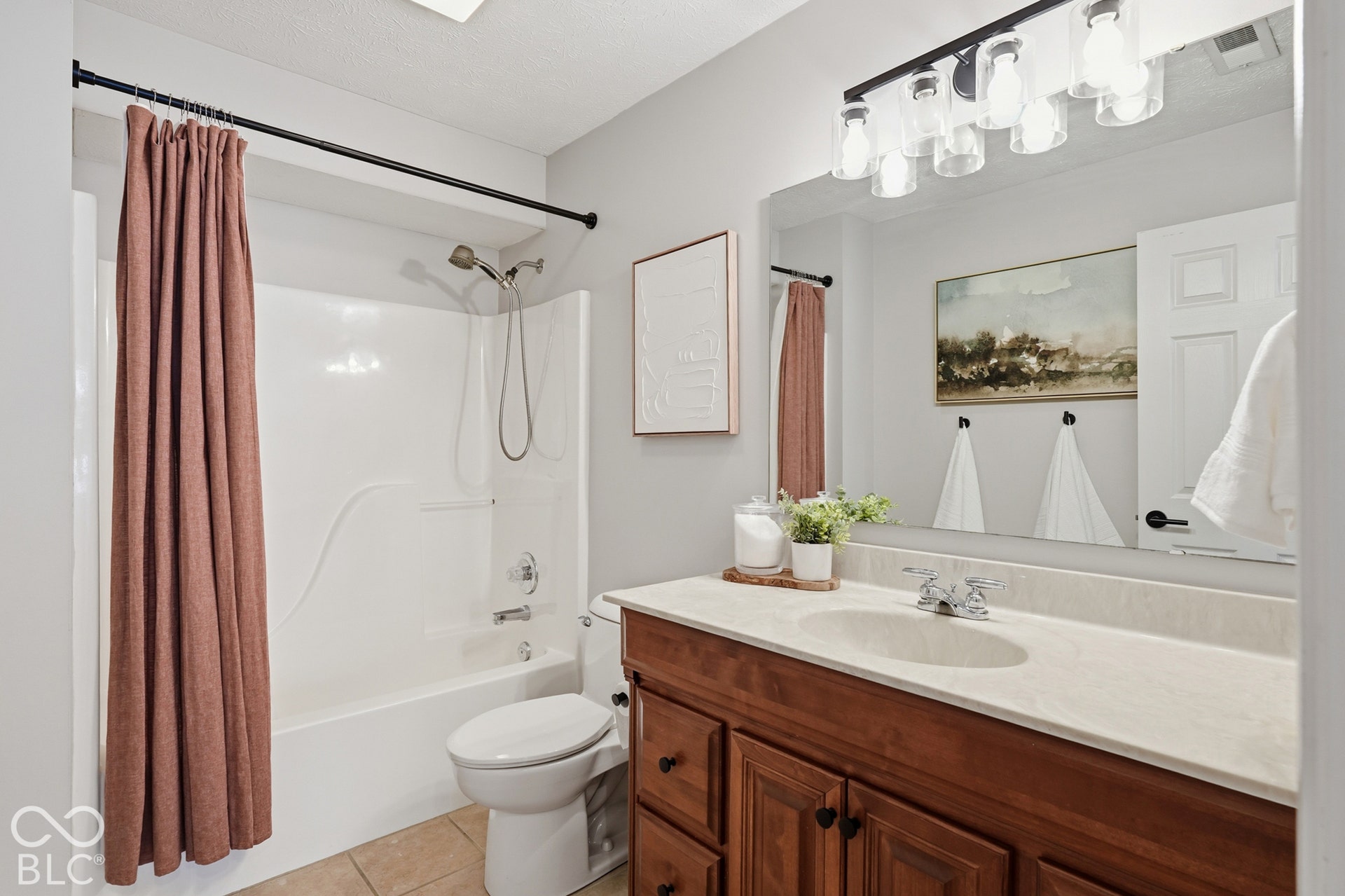 Vanity with a light-toned countertop and wood-finish cabinetry