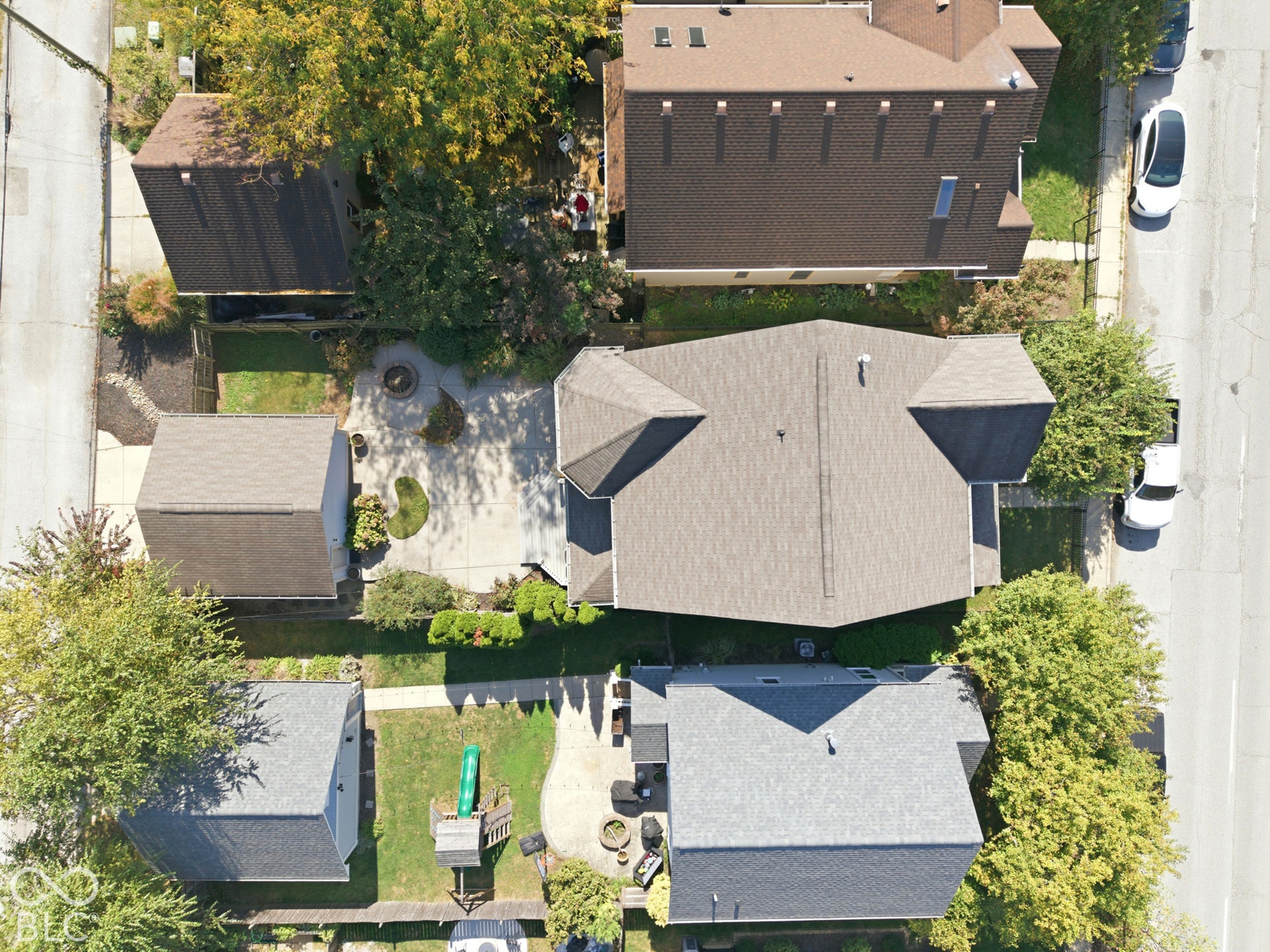 Expansive property featuring a main residence with a multi-gabled roof, an auxiliary structure with a gabled roof, and a paved driveway