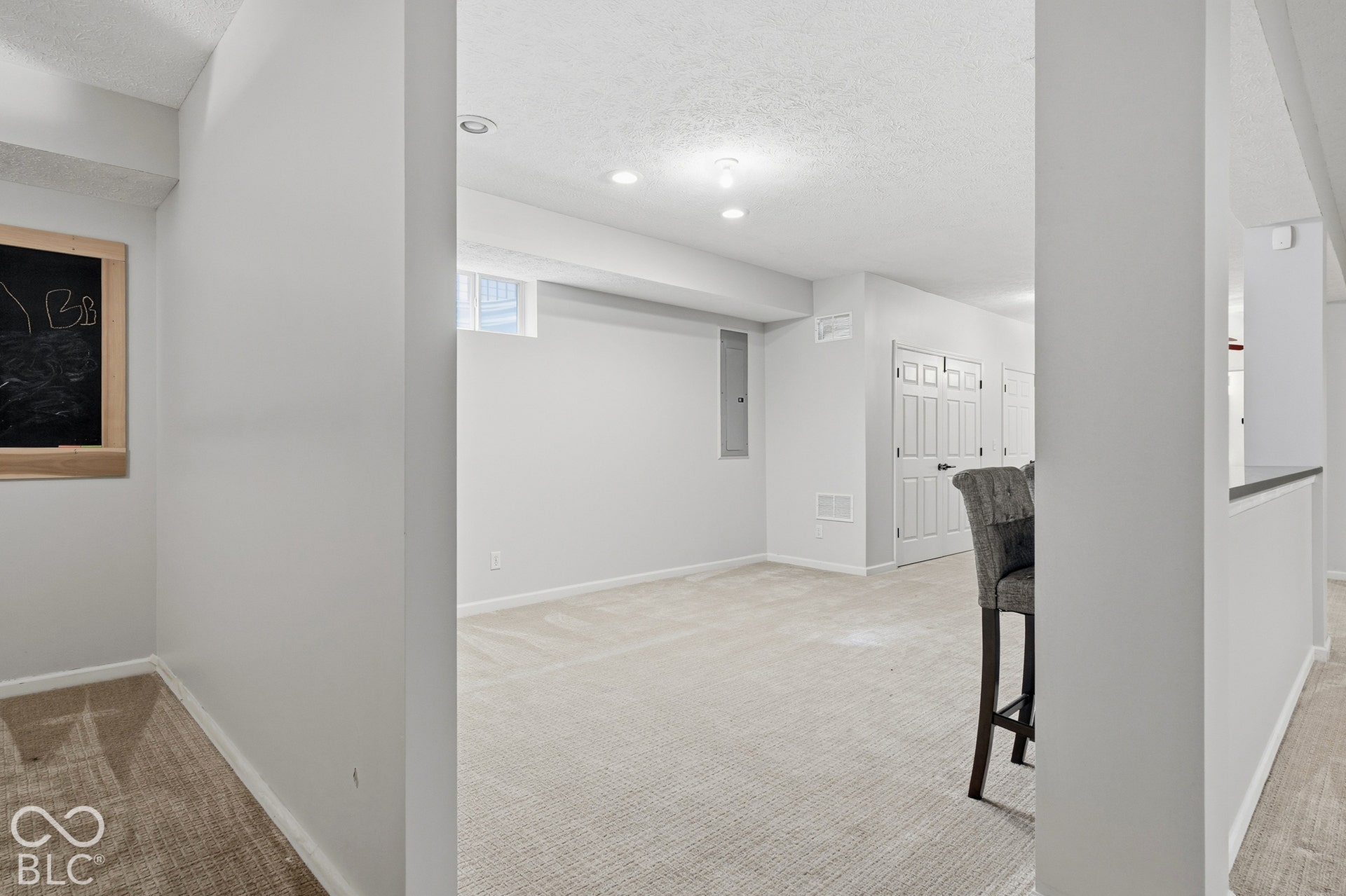 Recessed lighting illuminates the carpeted floor