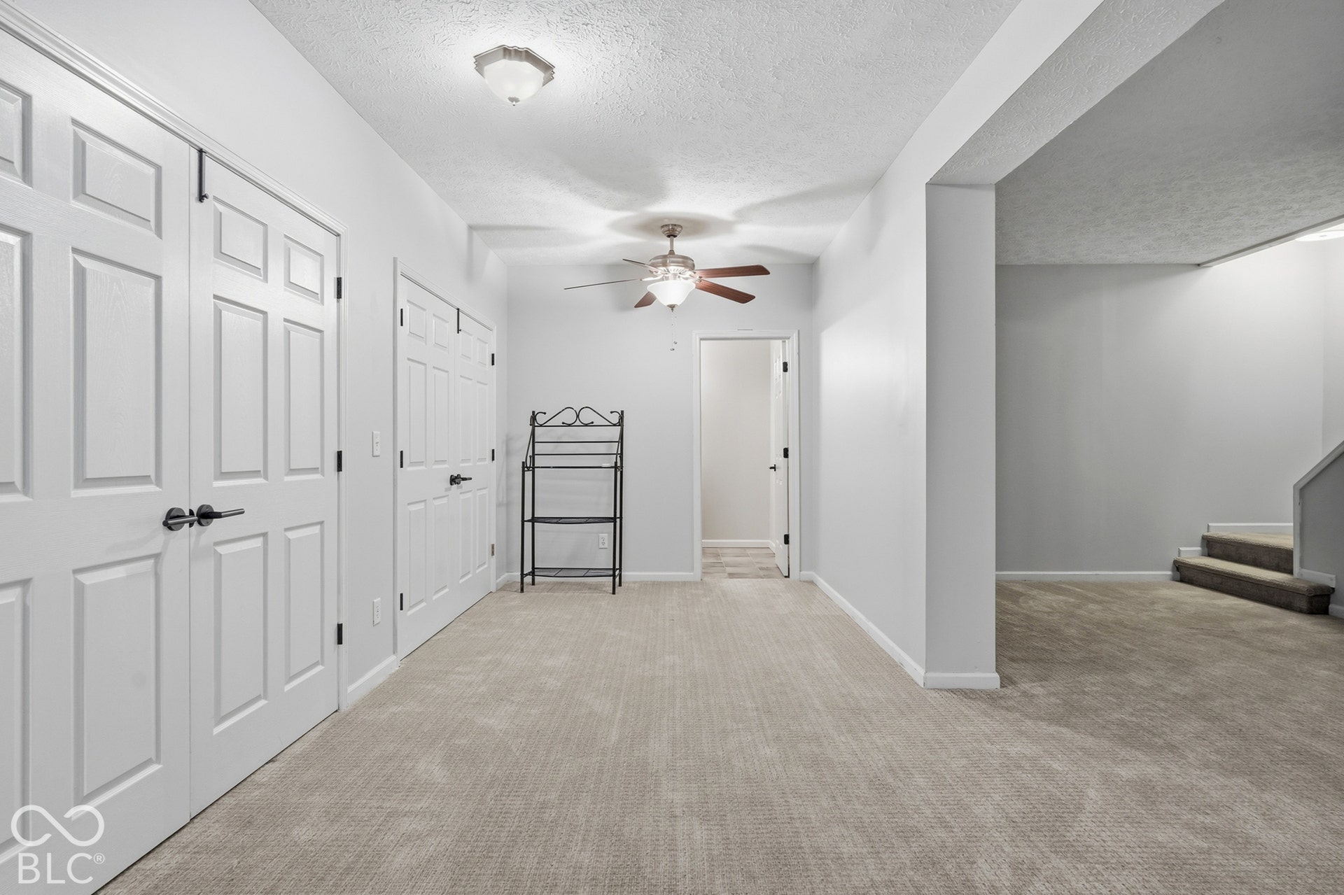 Plush carpeted flooring, multiple panel doors, recessed lighting, and a ceiling fan with integrated lighting