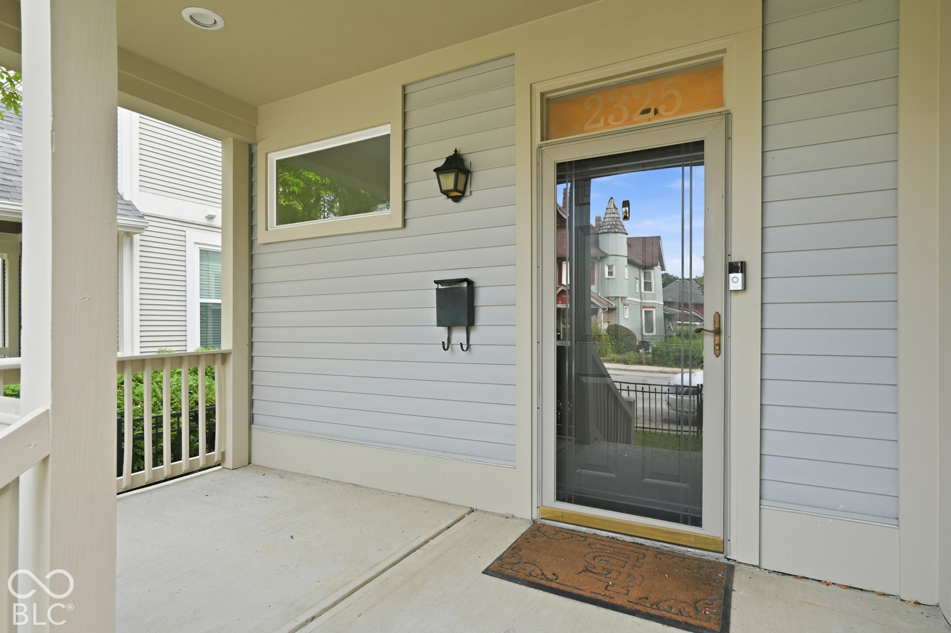 Covered concrete porch with light blue horizontal siding