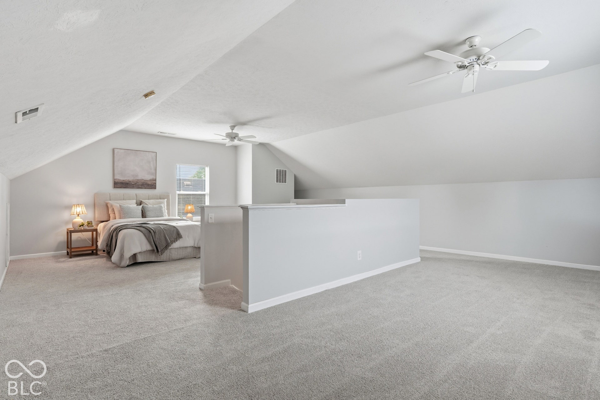 Carpeted loft area featuring a partial wall and sloped ceilings