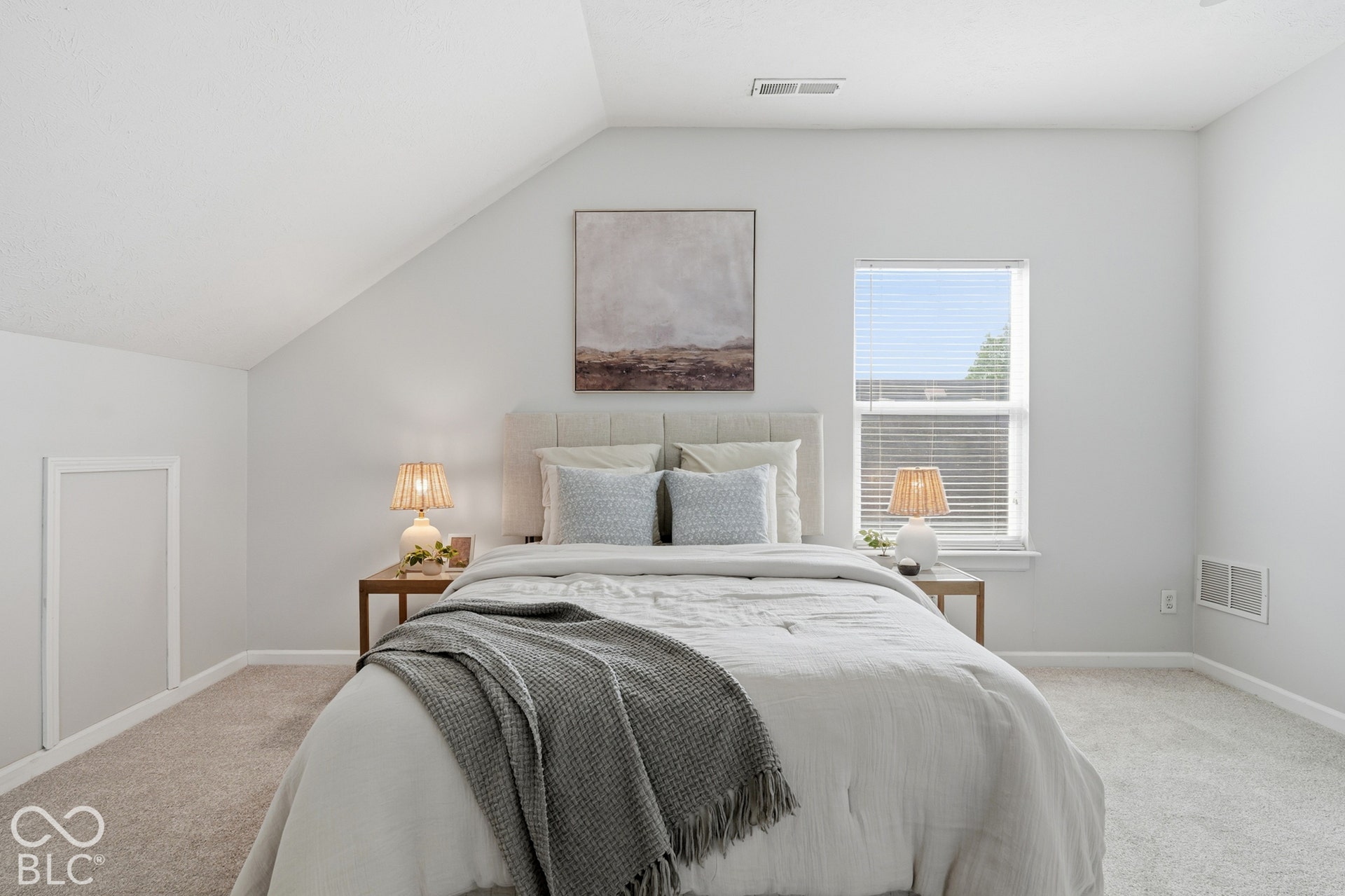 Vaulted ceiling, single window with blinds, light-colored carpeting, and light gray wall finish