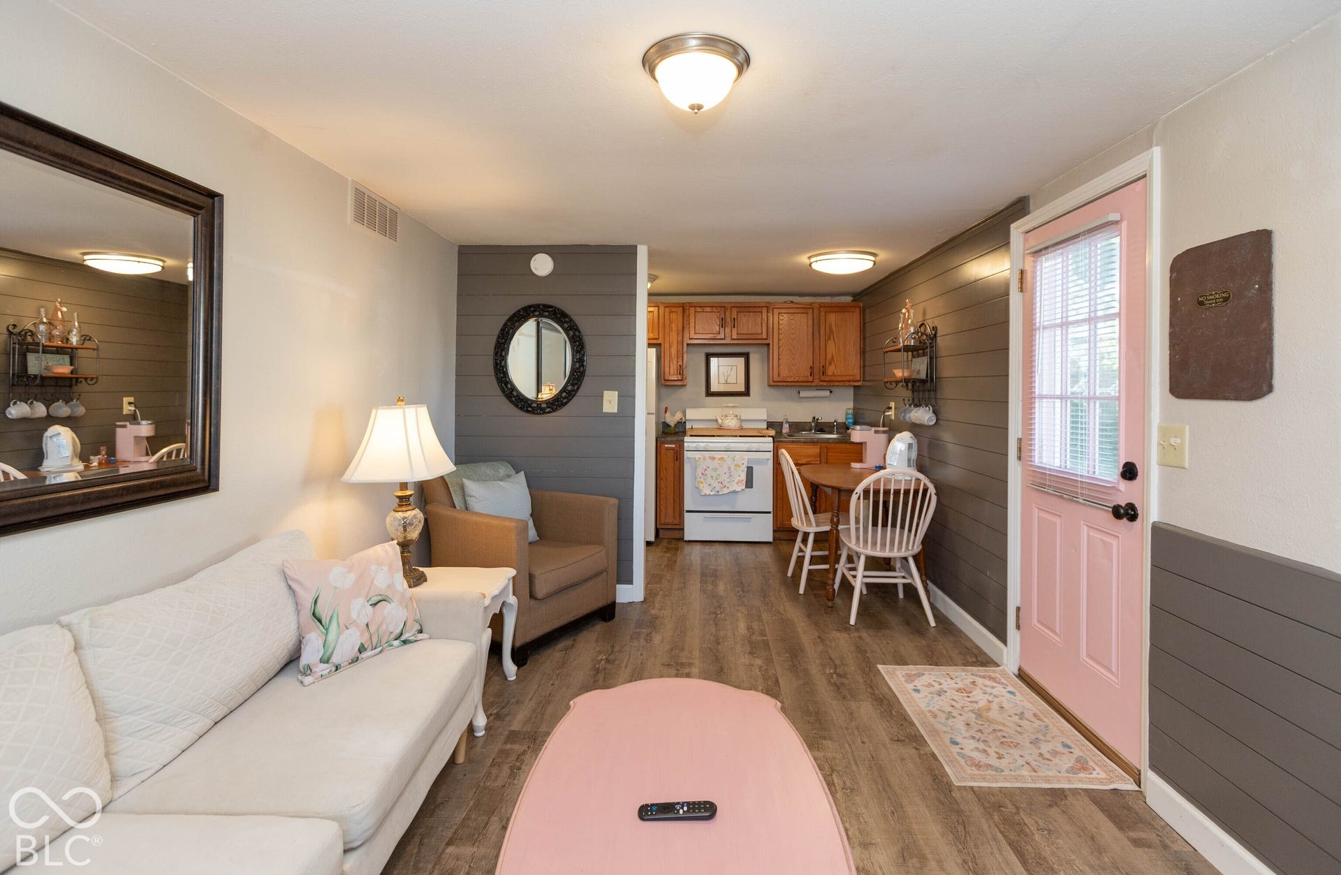 Wood-finish flooring throughout, with a visible kitchen area featuring wood cabinetry