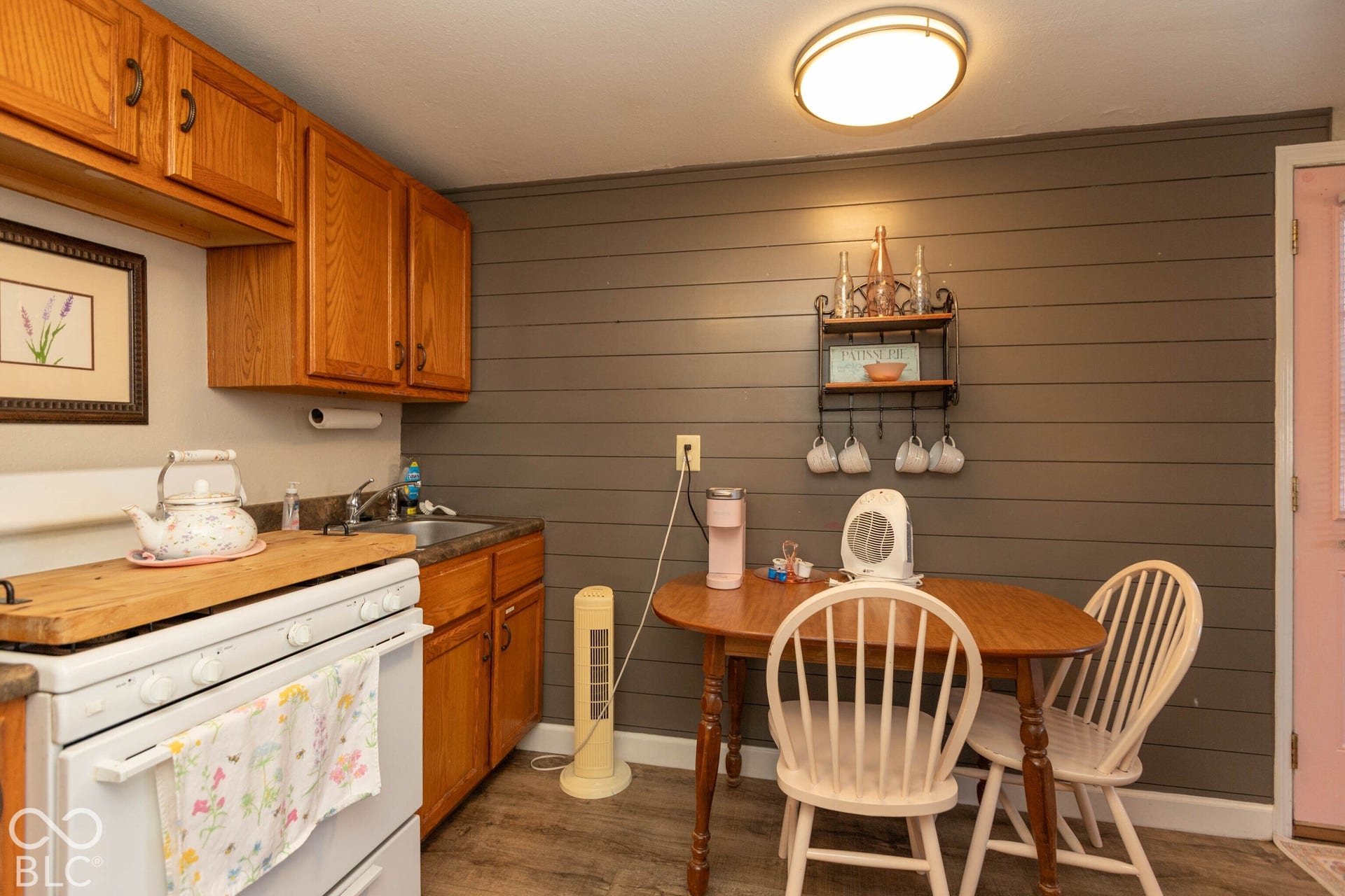 Kitchenette with wood-finish flooring, wood cabinetry, and a stainless steel sink