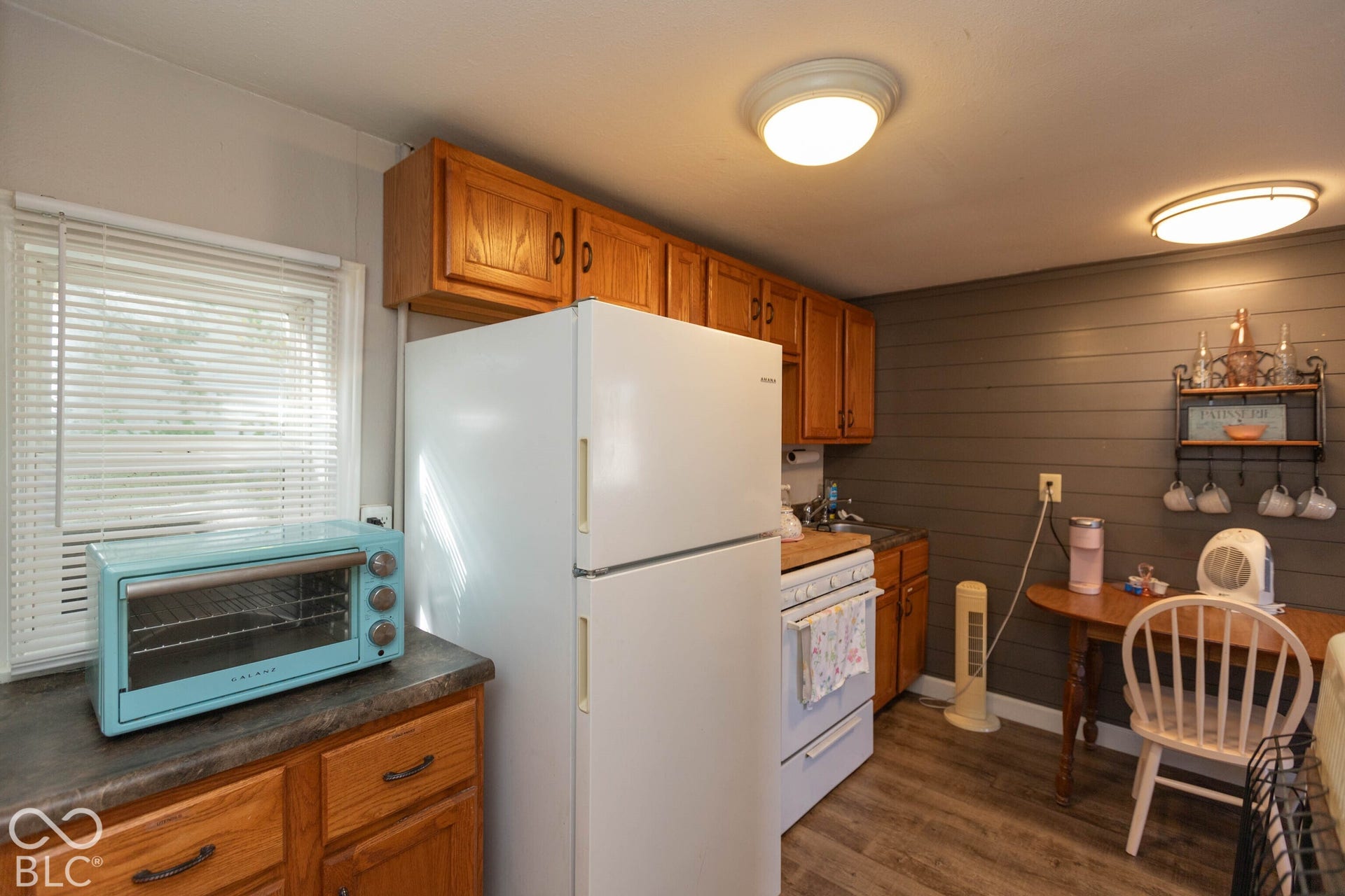 Kitchen featuring wood-finish cabinetry, a white refrigerator, and a white range