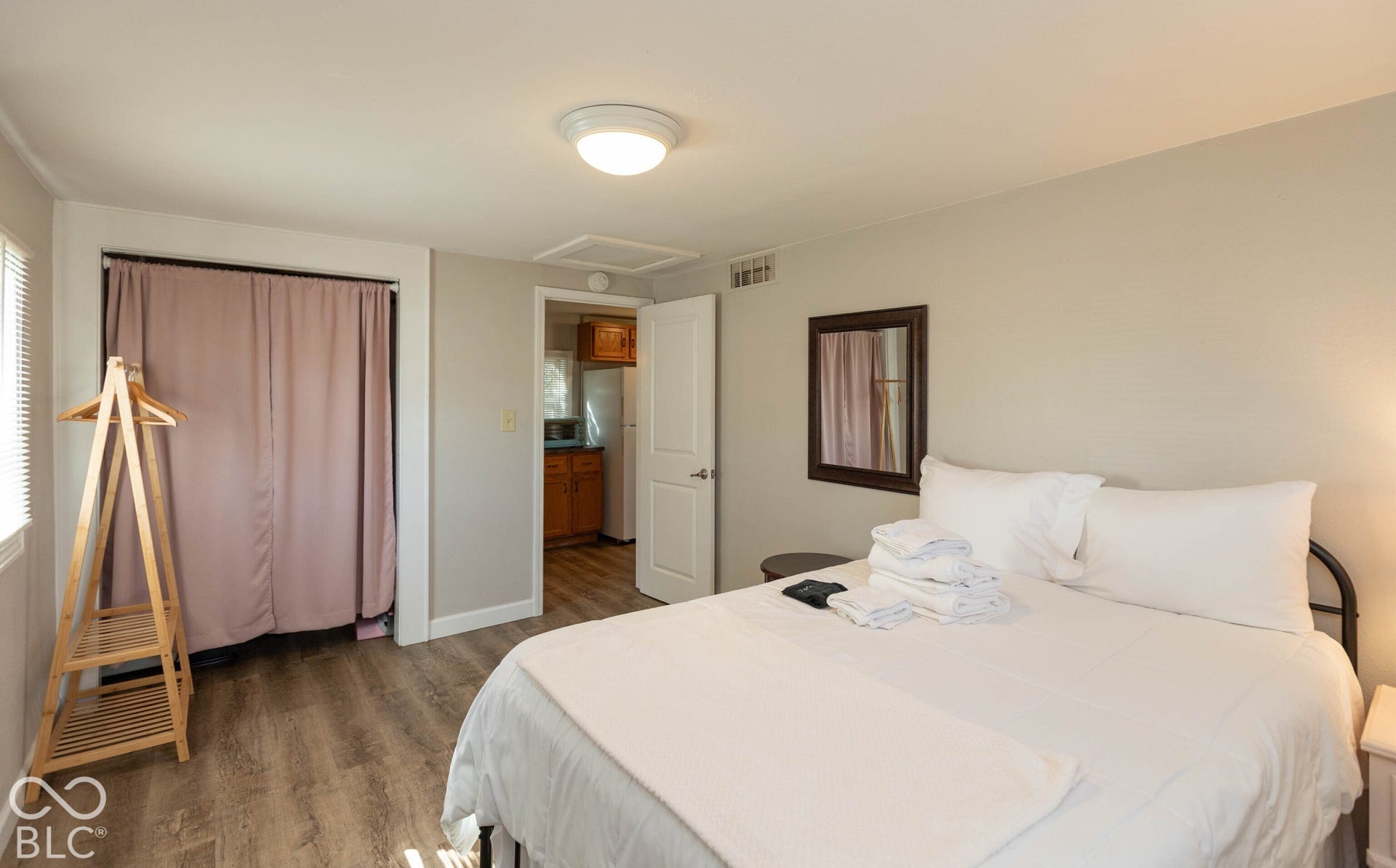 Wood-finish flooring, neutral wall paint, and a built-in closet with privacy curtains