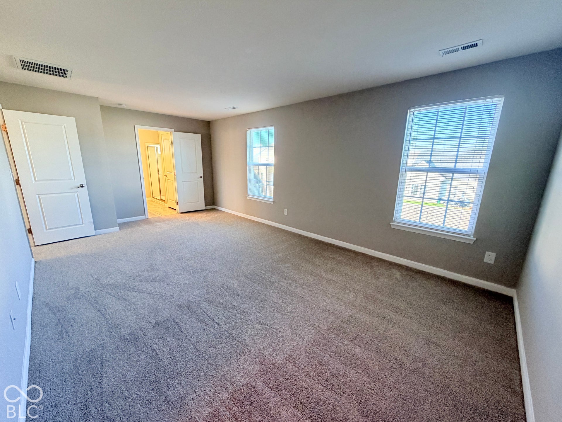 652 Classic Lane, Greenwood, IN 46143 Spacious room with carpeted flooring, two windows with blinds, and light gray painted walls