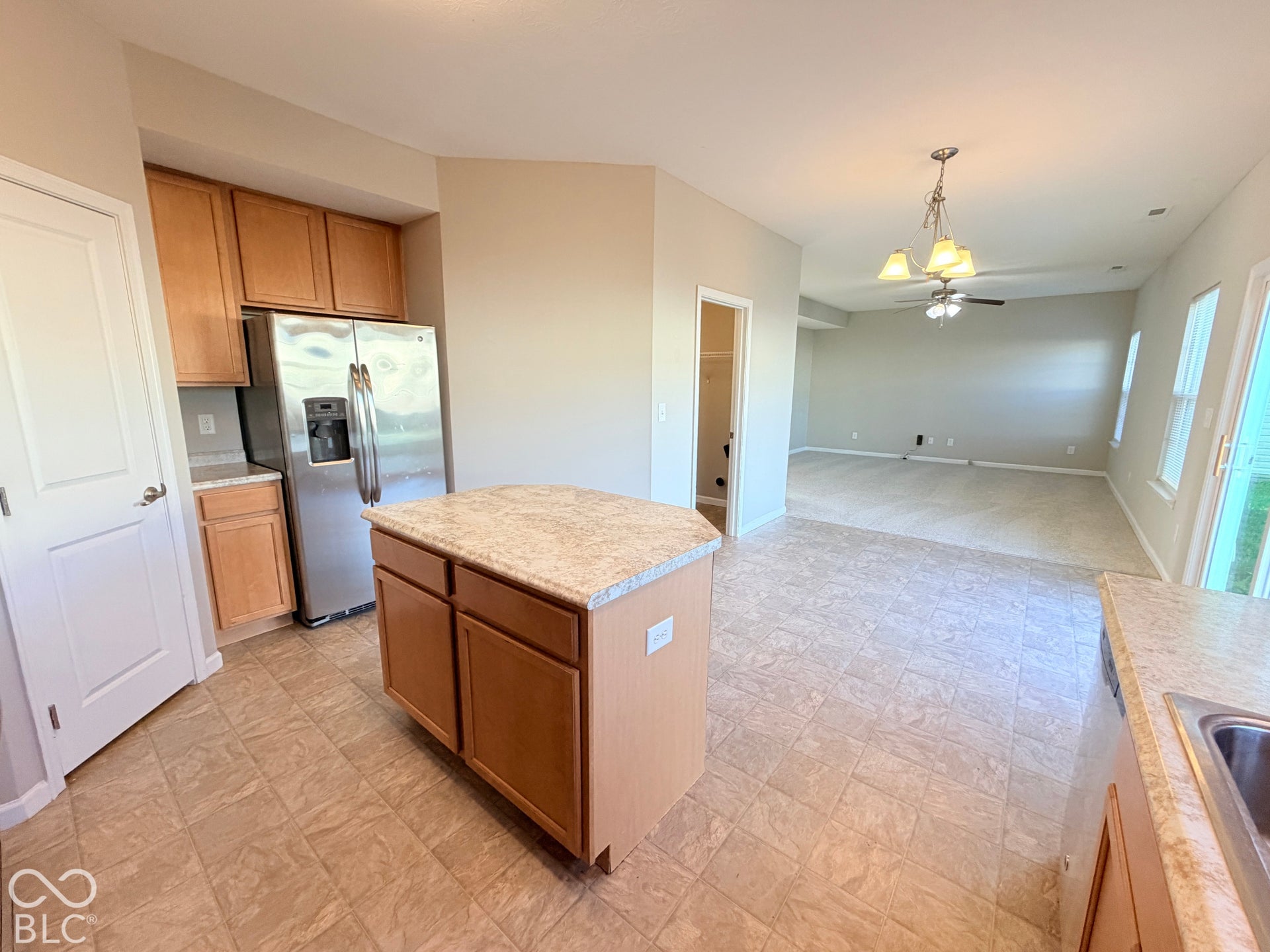 652 Classic Lane, Greenwood, IN 46143 Kitchen featuring an island with stone-finish countertop, stainless steel refrigerator, wood-finish cabinetry, and tile flooring