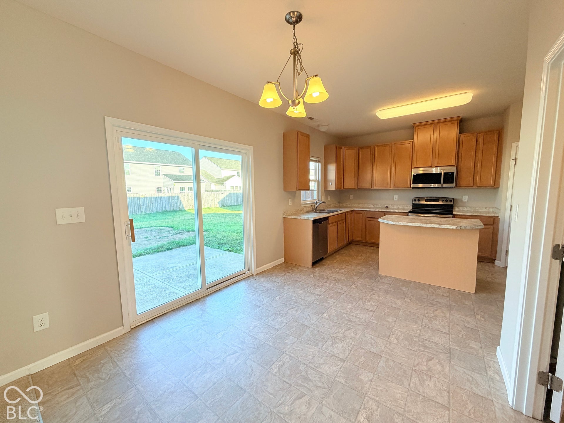 652 Classic Lane, Greenwood, IN 46143 Kitchen featuring wood-finish cabinetry, stainless steel appliances, a center island with countertop seating, and a ceiling-mounted light fixture