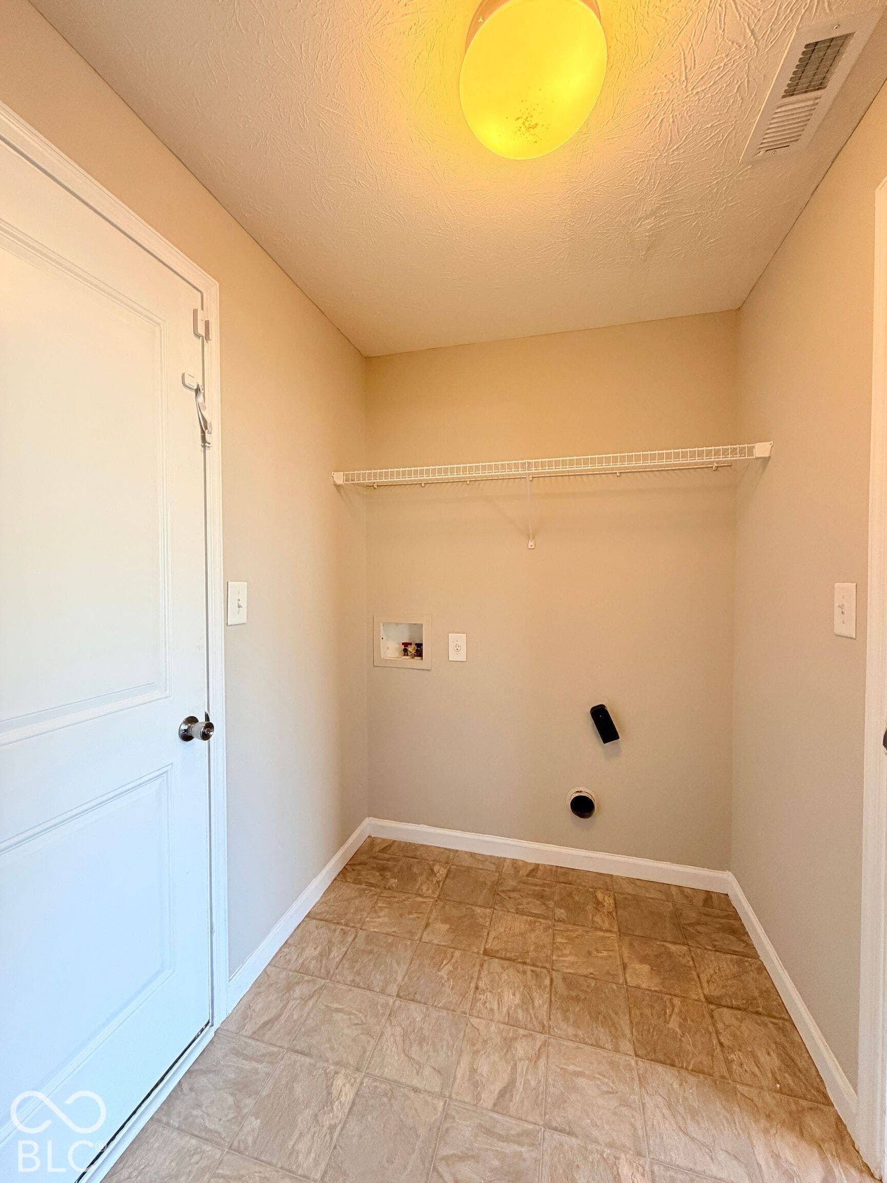 652 Classic Lane, Greenwood, IN 46143 Laundry area featuring a wire shelf, light-toned walls, and patterned tile flooring