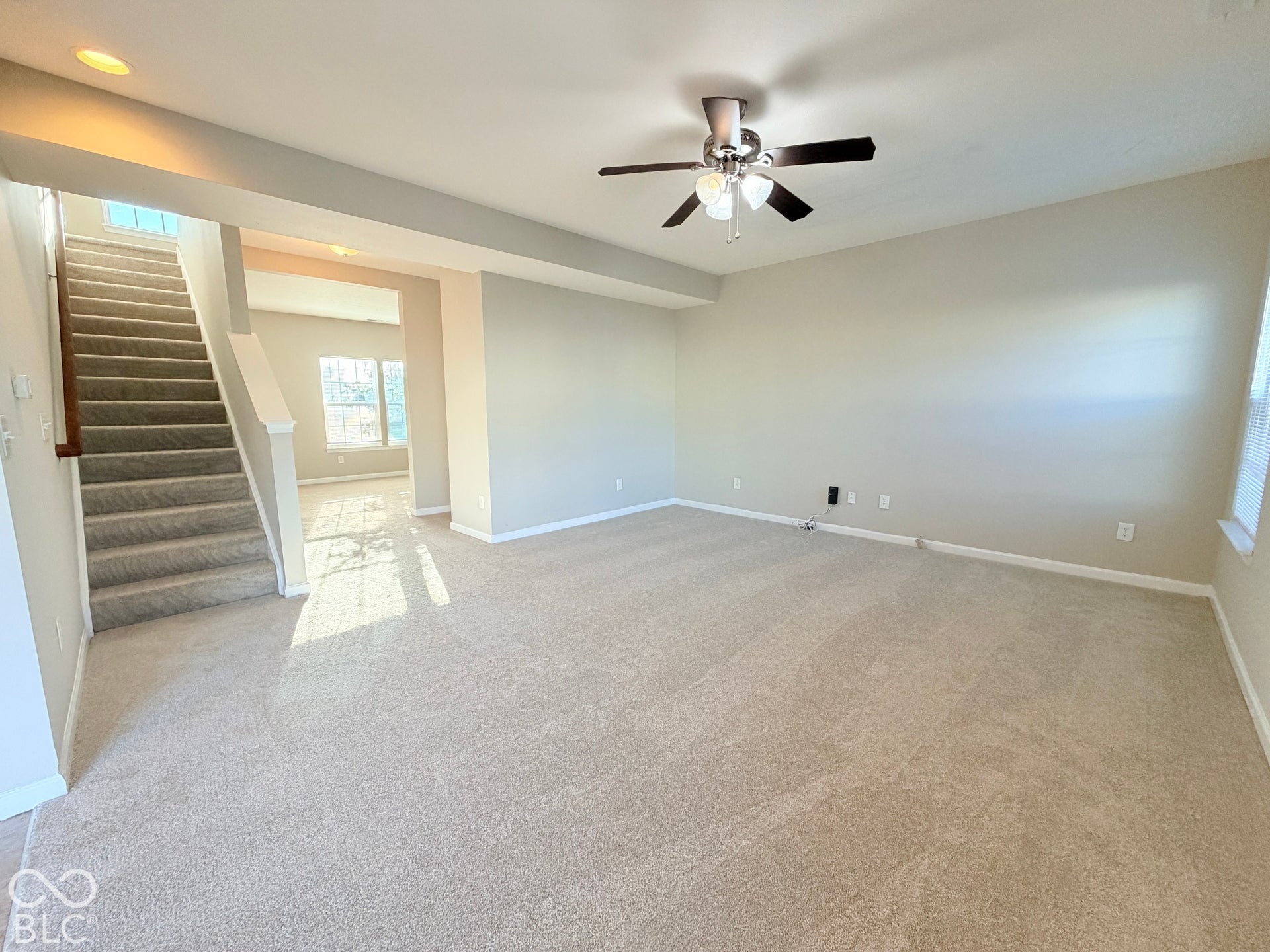 652 Classic Lane, Greenwood, IN 46143 Plush carpeted flooring throughout, overhead ceiling fan with lighting, staircase with carpeted treads and wood handrail, and recessed ceiling lighting