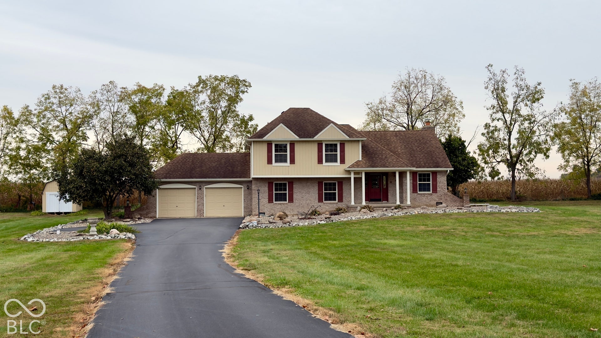 4034 W State Road 135 W, Trafalgar, IN 46181 Two-story exterior with a two-car garage, brick facade, and a covered front porch with white columns