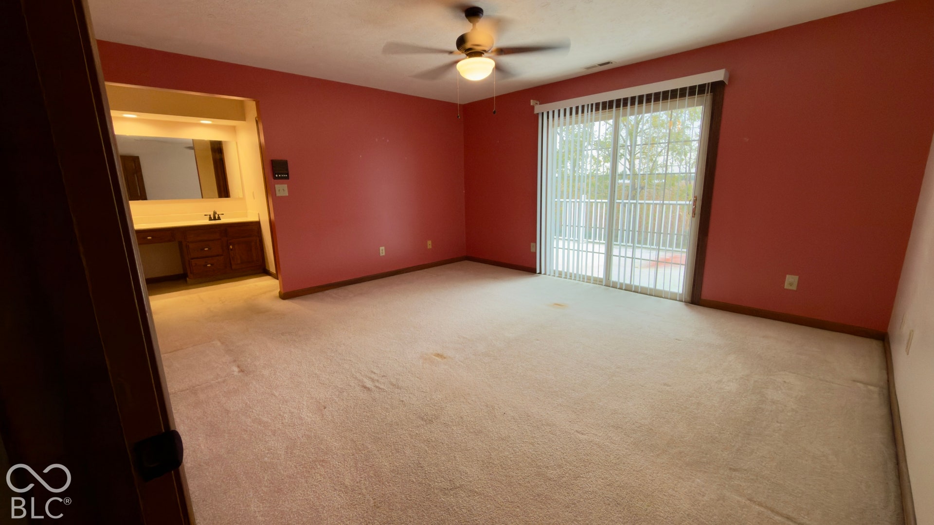 4034 W State Road 135 W, Trafalgar, IN 46181 Sliding glass door leading to a balcony, ceiling fan, carpeted flooring, and an integrated vanity with sink and mirror