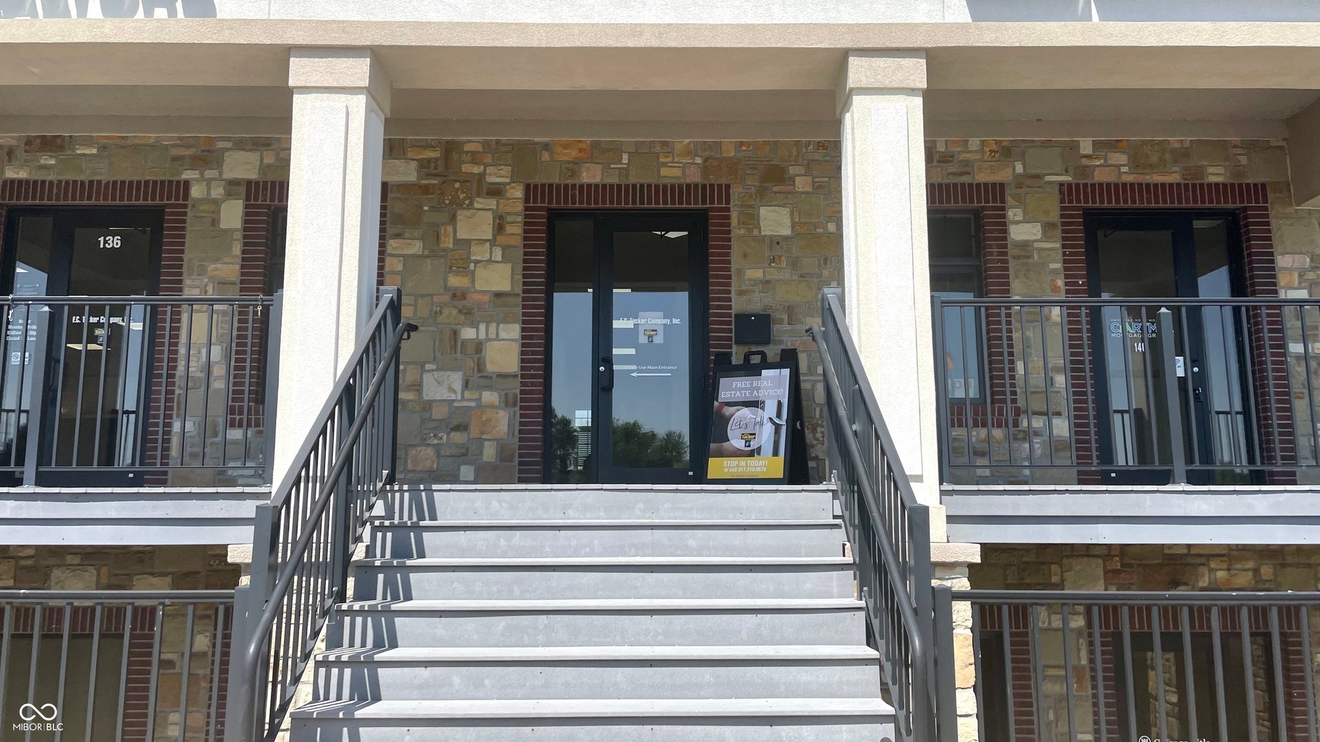 view of exterior entry with stone siding and a porch